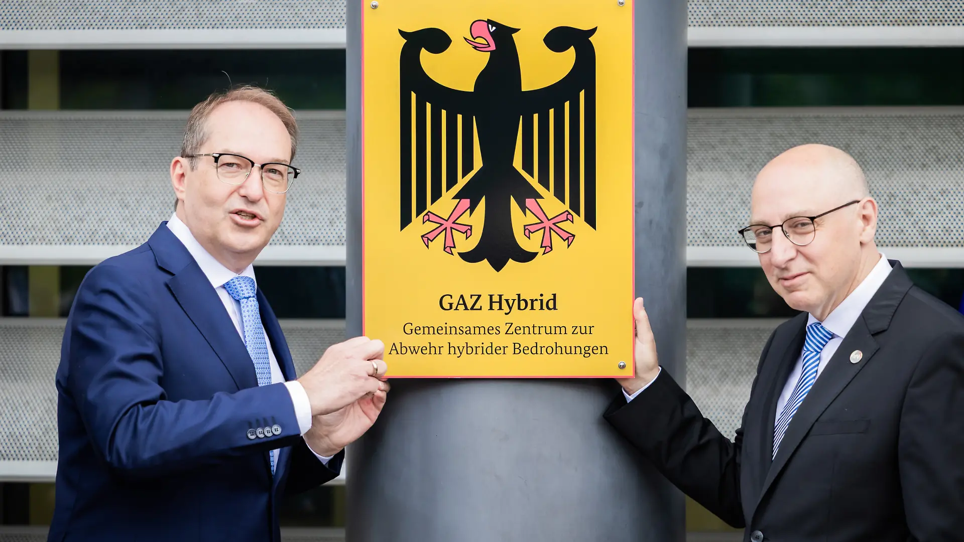 Alexander Dobrindt (CSU, l), Bundesinnenminister, schraubt im Beisein von Sinan Selen, Präsident des Bundesamtes für Verfassungsschutz, symbolisch bei der Einweihung des Gemeinsamen Zentrums zur Abwehr hybrider Bedrohungen (GAZ Hybrid) das entsprechende Schild an. Das neue Abwehrzentrum wird in Räumlichkeiten des Bundesamtes für Verfassungsschutz in Berlin-Treptow angesiedelt sein.