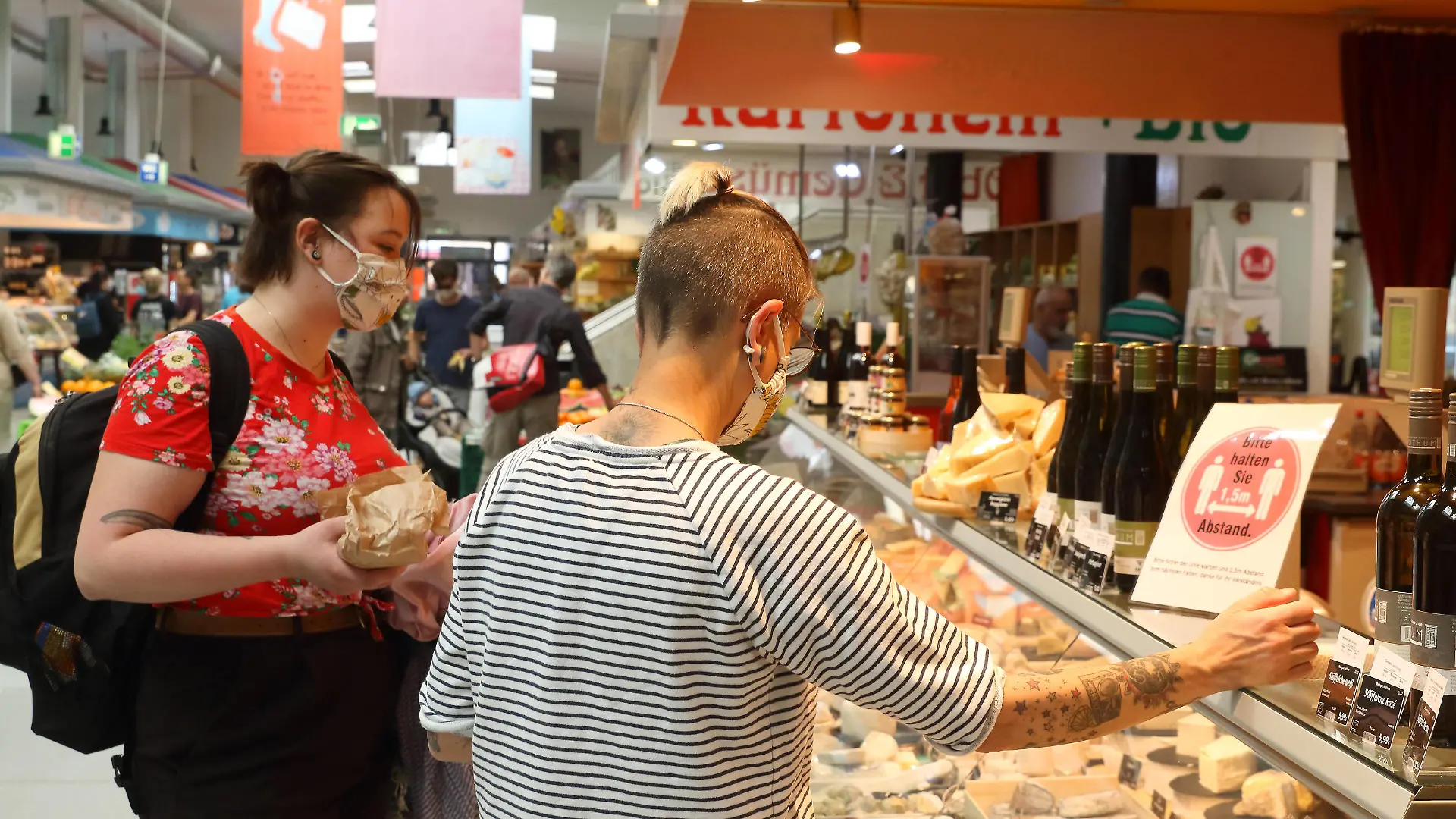  Einkaufen mit Masken zum Schutz vor dem Coronavirus - Coronakrise - Maskenpflicht - COVID-19 - SARS-CoV-2 - Corona-Krise - Corona-Pandemie - Virus - Viren - Coronaeinschränkungen - Angst vor dem Coronavirus - Schutz vor dem Coronavirus - Shoppen mit Maske - Shoppen mit Atemschutzmaske - Sichtbare Corona-Maßnahme - Berlin, Deutschland, DEU, GER, 28.04.2020 - Berlin Friedrichshain-Kreuzberg Ortsteil Kreuzberg: Zwei Frauen mit Atemschutzmasken tätigen ihren Einkauf am Käsestand. Schild auf dem Tresen: Bitte halten Sie 1,5m Abstand *** Shopping with masks for protection against the coronavirus Corona crisis Mask obligation COVID 19 SARS CoV 2 Corona crisis Corona pandemic virus Viruses Corona restrictions Fear of the coronavirus Protection against the coronavirus Shopping with a mask Shopping with a respirator Visible corona measure Be