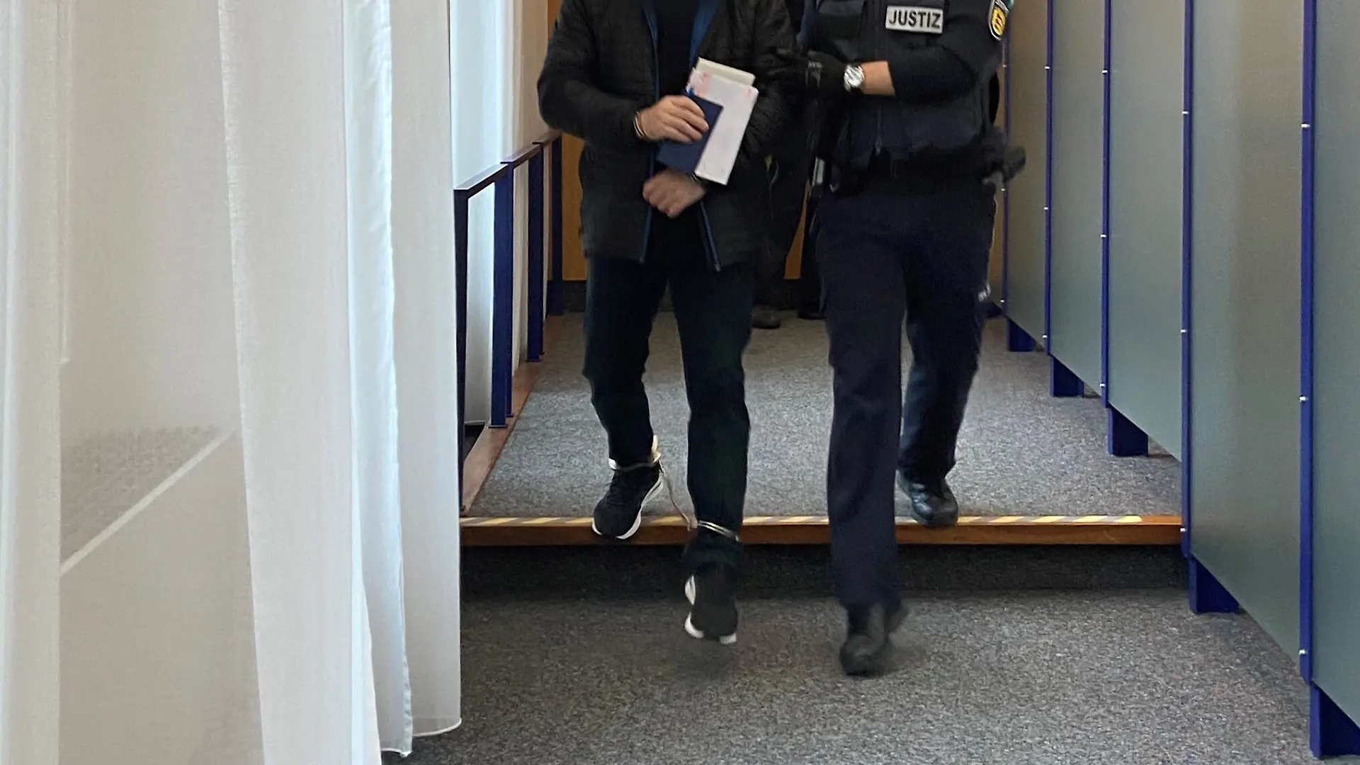 Ein Angeklagter (l) wird in den Gerichtssaal im Landgericht gebracht. Der Mann aus dem Alb-Donau-Kreis soll den sexuellen Missbrauch von Kindern auf den Philippinen in Auftrag gegeben und dafür bezahlt haben, sich die schweren Missbrauchshandlungen per Livestream ansehen zu können. Am Donnerstag hat der Prozess begonnen. +++ dpa-Bildfunk +++