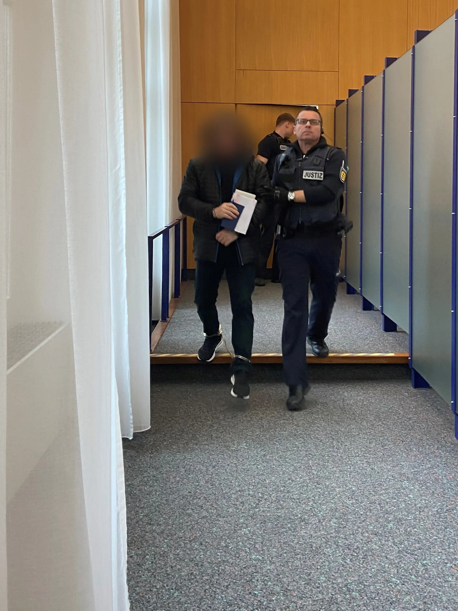Ein Angeklagter (l) wird in den Gerichtssaal im Landgericht gebracht. Der Mann aus dem Alb-Donau-Kreis soll den sexuellen Missbrauch von Kindern auf den Philippinen in Auftrag gegeben und dafür bezahlt haben, sich die schweren Missbrauchshandlungen per Livestream ansehen zu können. Am Donnerstag hat der Prozess begonnen. +++ dpa-Bildfunk +++