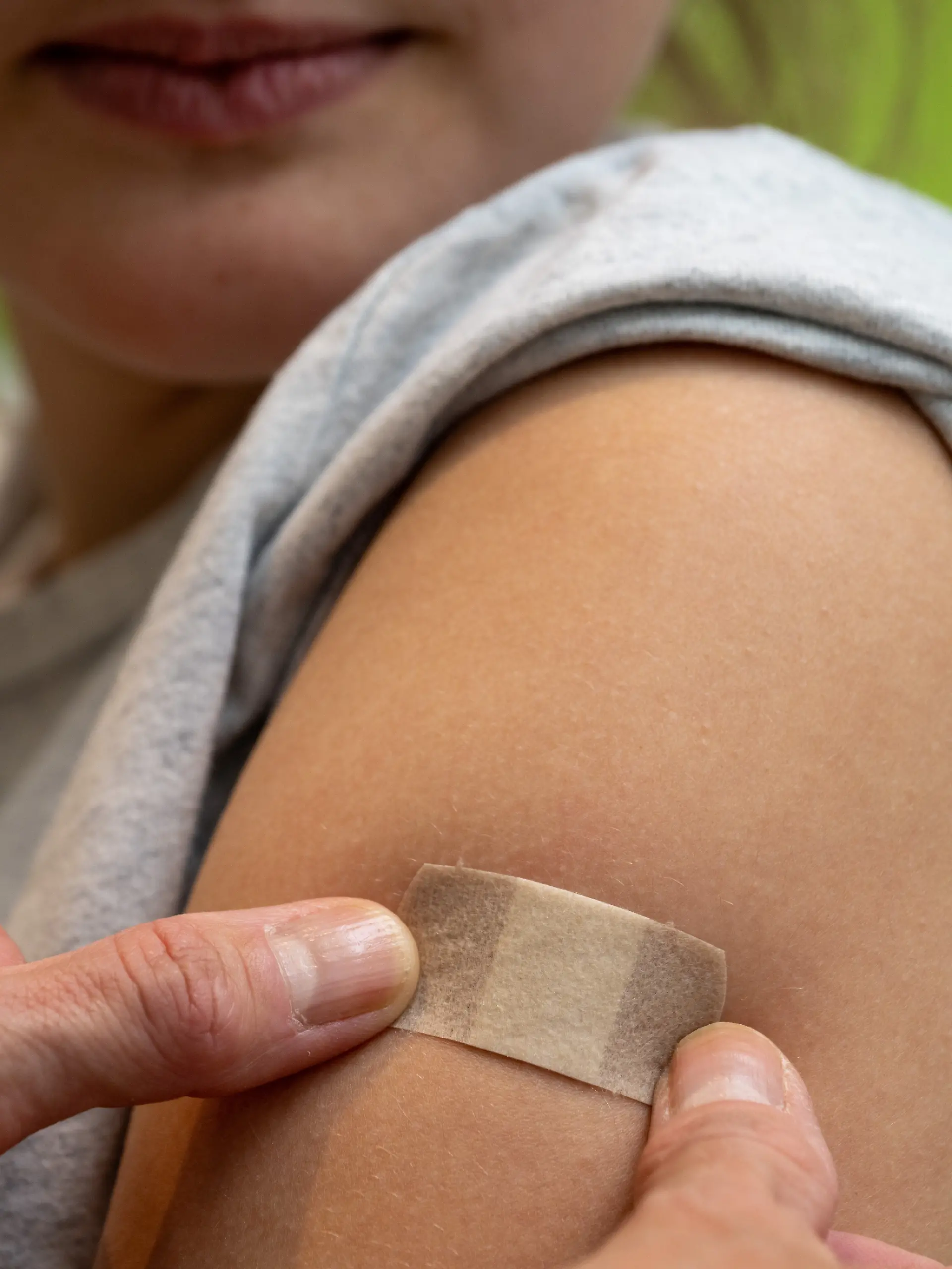 Gynäkologin Stephanie Eder versorgt an Patientin Clara nach der HPV-Impfung in einer Frauenarztpraxis die Injektionsstelle. Empfohlen ist die HPV-Impfung von der STIKO ab dem Alter von 9 Jahren. Ist die Impfung nicht bis zum Alter von 14 Jahren erfolgt, empfiehlt die STIKO, diese noch bis zum Alter von 17 Jahren nachzuholen.