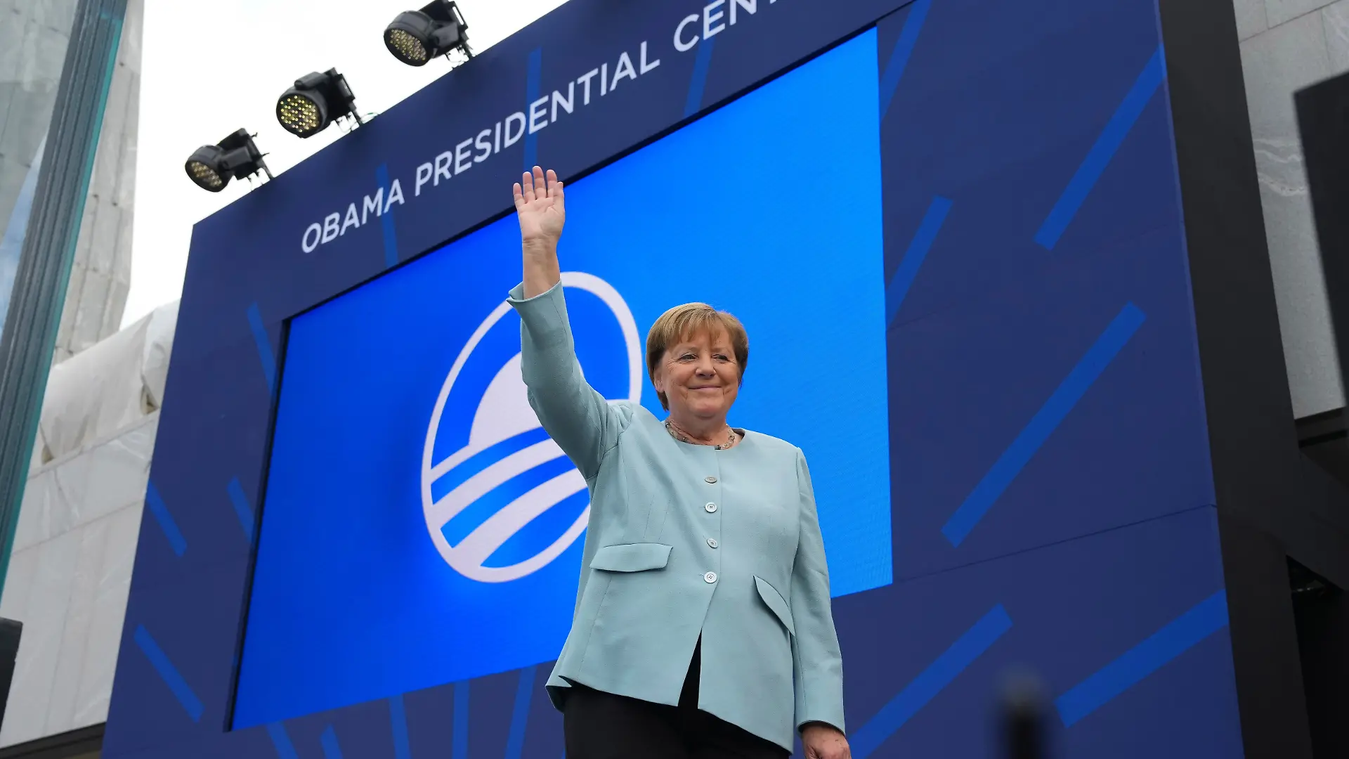 Die ehemalige Bundeskanzlerin Angela Merkel (CDU) winkt als sie am Donnerstag, dem 18. Juni 2026, in Chicago bei der Einweihungsfeier für das Obama Presidential Center vorgestellt wird. +++ dpa-Bildfunk +++