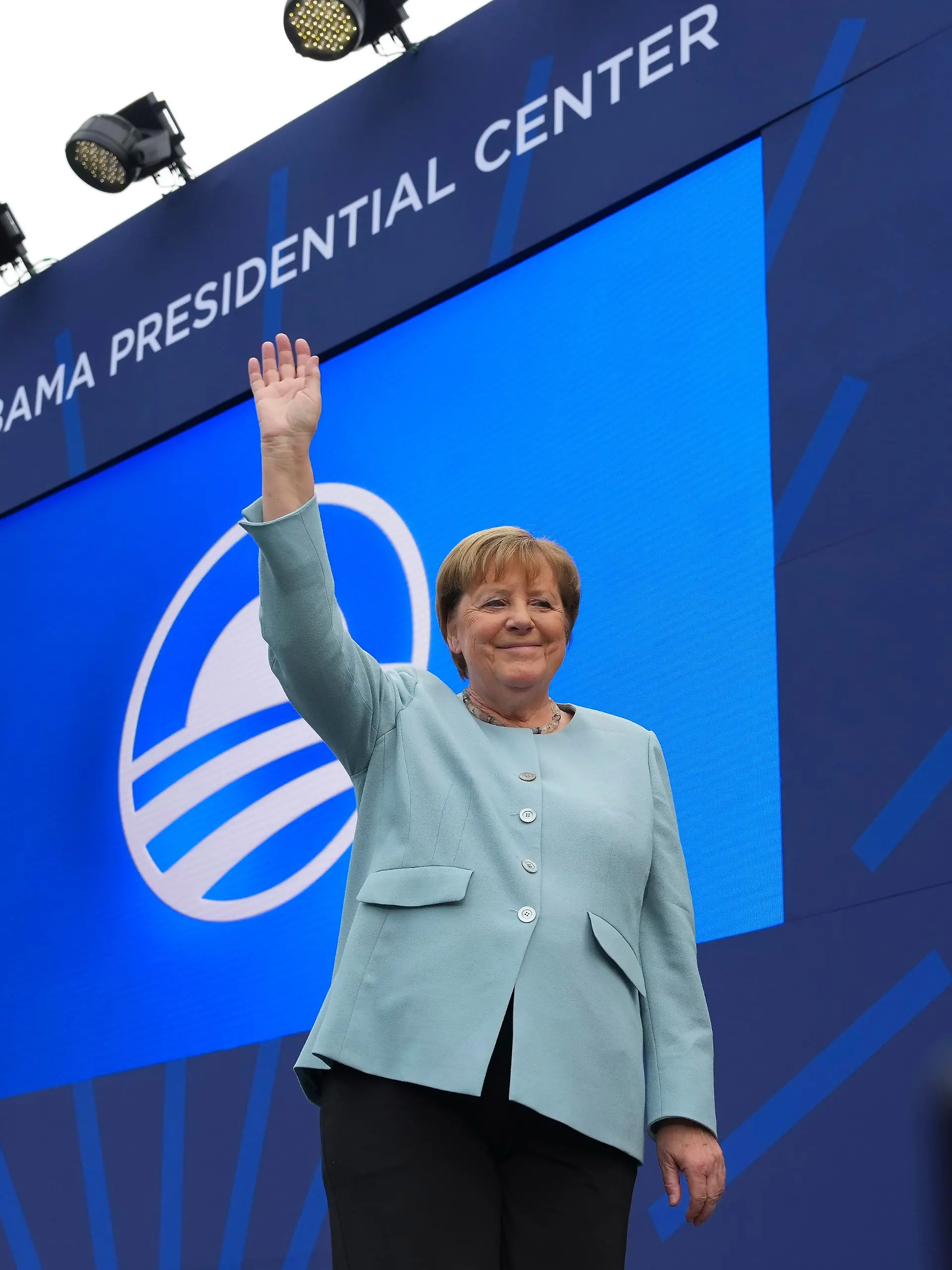 Die ehemalige Bundeskanzlerin Angela Merkel (CDU) winkt als sie am Donnerstag, dem 18. Juni 2026, in Chicago bei der Einweihungsfeier für das Obama Presidential Center vorgestellt wird. +++ dpa-Bildfunk +++