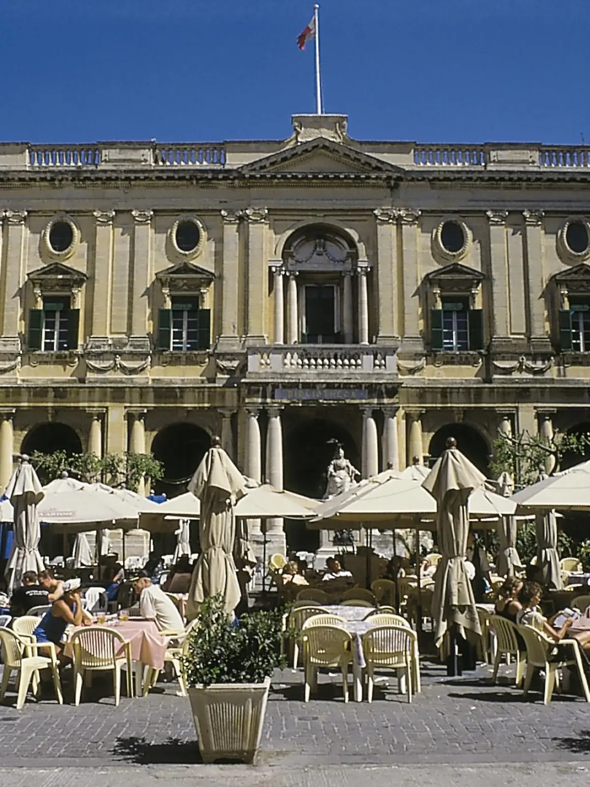 Gebäude der Nationalbibliothek von Malta in La Valetta. Auf dem Vorplatz ein Straßencafé.