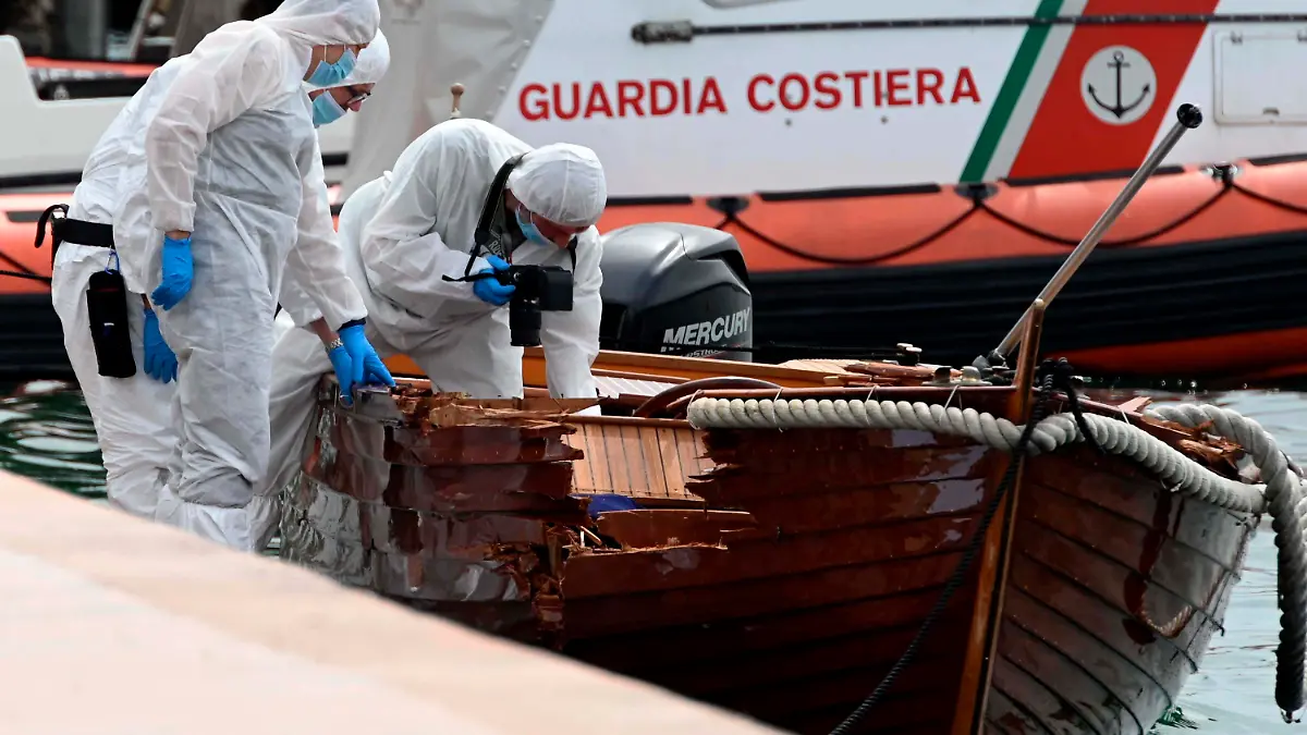 ARCHIV - 20.06.2021, Italien, Salo: Italienische Forensiker begutachten den Schaden an einem Boot. Ein Motorboot, besetzt mit zwei Deutschen, hatte das kleine Boot eines italienischen Paares gerammt. Der 37 Jahre alte Mann und seine 25-jährige Begleiterin kamen dabei ums Leben. (zu dpa "Nach Unfall auf Gardasee: Verdächtiger Deutscher vernommen") Foto: Gabriele Strada/AP/dpa +++ dpa-Bildfunk +++