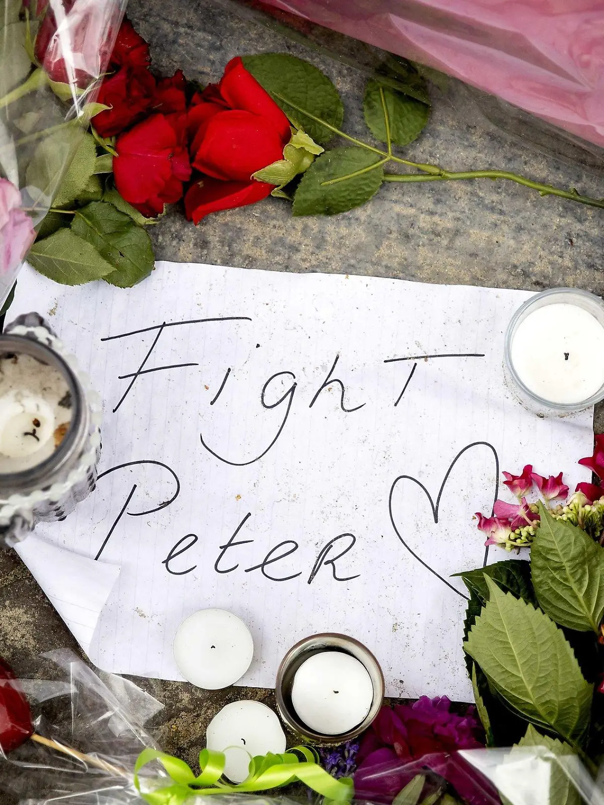 07.07.2021, Niederlande, Amsterdam: Blumen, Kerzen und eine Botschaft mit "Fight Peter" liegen am Tatort. Der auch international bekannte Kriminalreporter Peter R. de Vries war am Dienstagabend an dieser Stelle niedergeschossen und lebensgefährlich verletzt worden. Foto: Koen Van Weel/ANP/dpa +++ dpa-Bildfunk +++