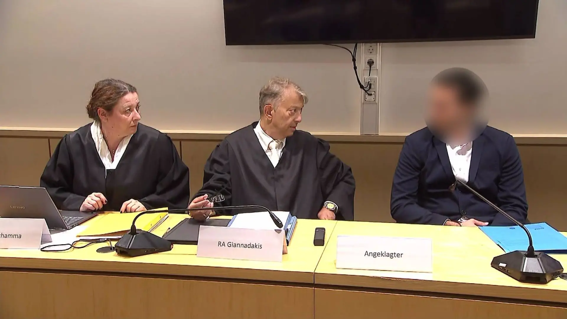 Der Angeklagte Ioanni V. sitzt neben seinem Verteidiger im Gerichtssaal.