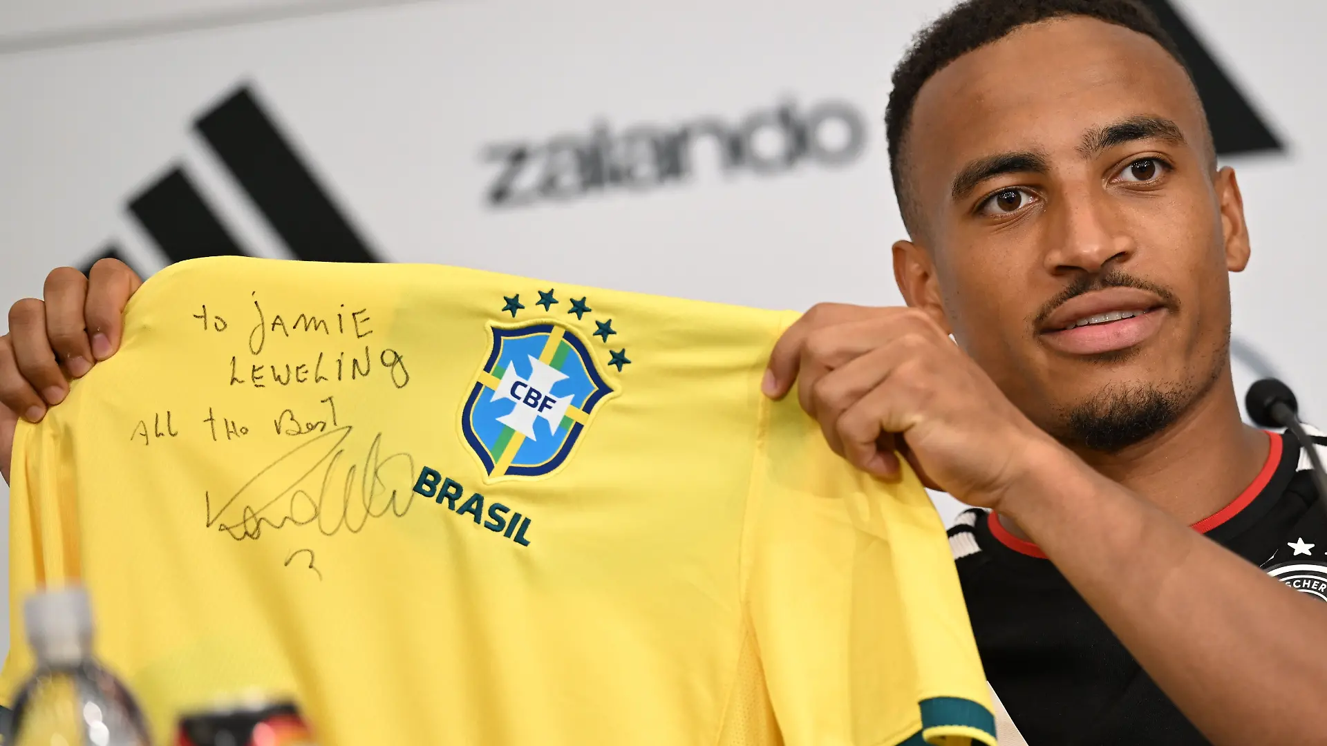 Vor dem letzten Gruppenspiel gegen Ecuador zeigt Jamie Leweling bei einer Pressekonferenz ein signiertes Ronaldo-Trikot.