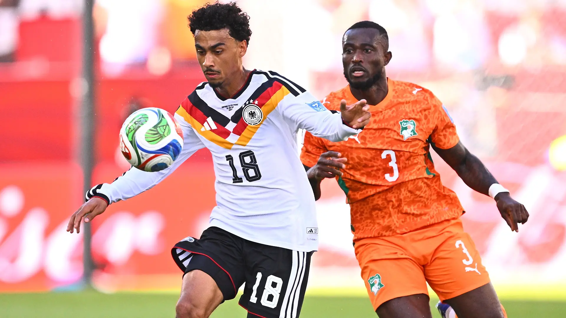 Fußball, Männer, WM 2026, Deutschland - Elfenbeinküste, Vorrunde, Gruppe E, Spieltag 2, Toronto-Stadion, Nathaniel Brown (Deutschland) und Ghislain Konan (Elfenbeinküste) kämpfen um den Ball. ACHTUNG: Gemäß den Auflagen der FIFA dürfen die Bilder ausschließlich zur redaktionellen Verwendung genutzt werden. Eine kommerzielle Nutzung ist ausgeschlossen. Zudem dürfen keine videoähnlichen Sequenzen erstellt werden, und es dürfen keine Veränderungen weder im Vordergrund noch im Hintergrund am Bild vorgenommen werden.