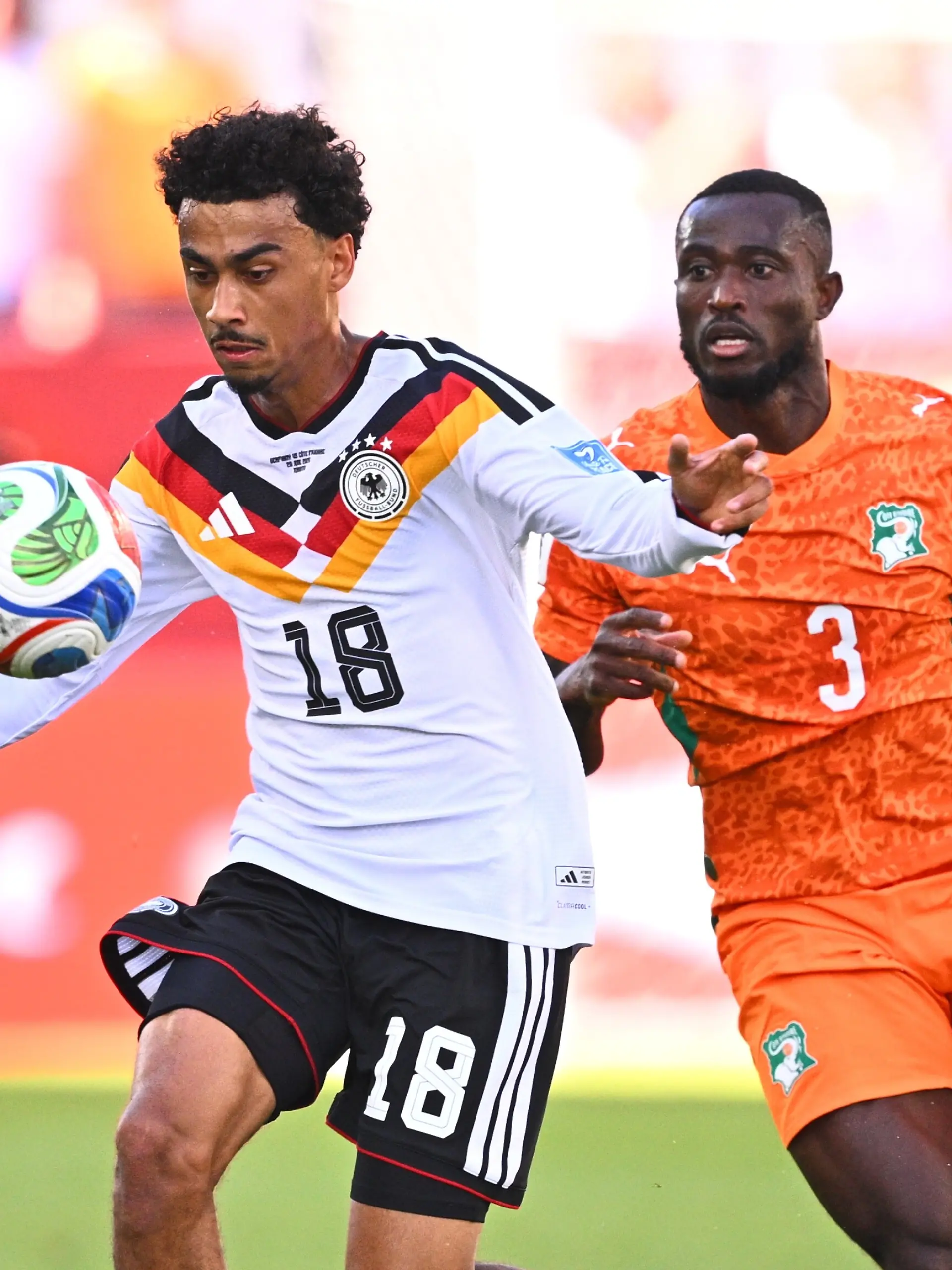Fußball, Männer, WM 2026, Deutschland - Elfenbeinküste, Vorrunde, Gruppe E, Spieltag 2, Toronto-Stadion, Nathaniel Brown (Deutschland) und Ghislain Konan (Elfenbeinküste) kämpfen um den Ball. ACHTUNG: Gemäß den Auflagen der FIFA dürfen die Bilder ausschließlich zur redaktionellen Verwendung genutzt werden. Eine kommerzielle Nutzung ist ausgeschlossen. Zudem dürfen keine videoähnlichen Sequenzen erstellt werden, und es dürfen keine Veränderungen weder im Vordergrund noch im Hintergrund am Bild vorgenommen werden.