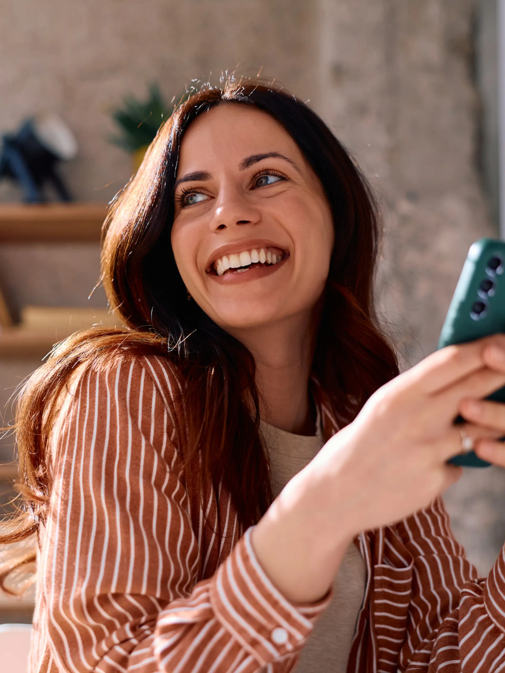 Frau freut sich mit einem Smartphone in der Hand.