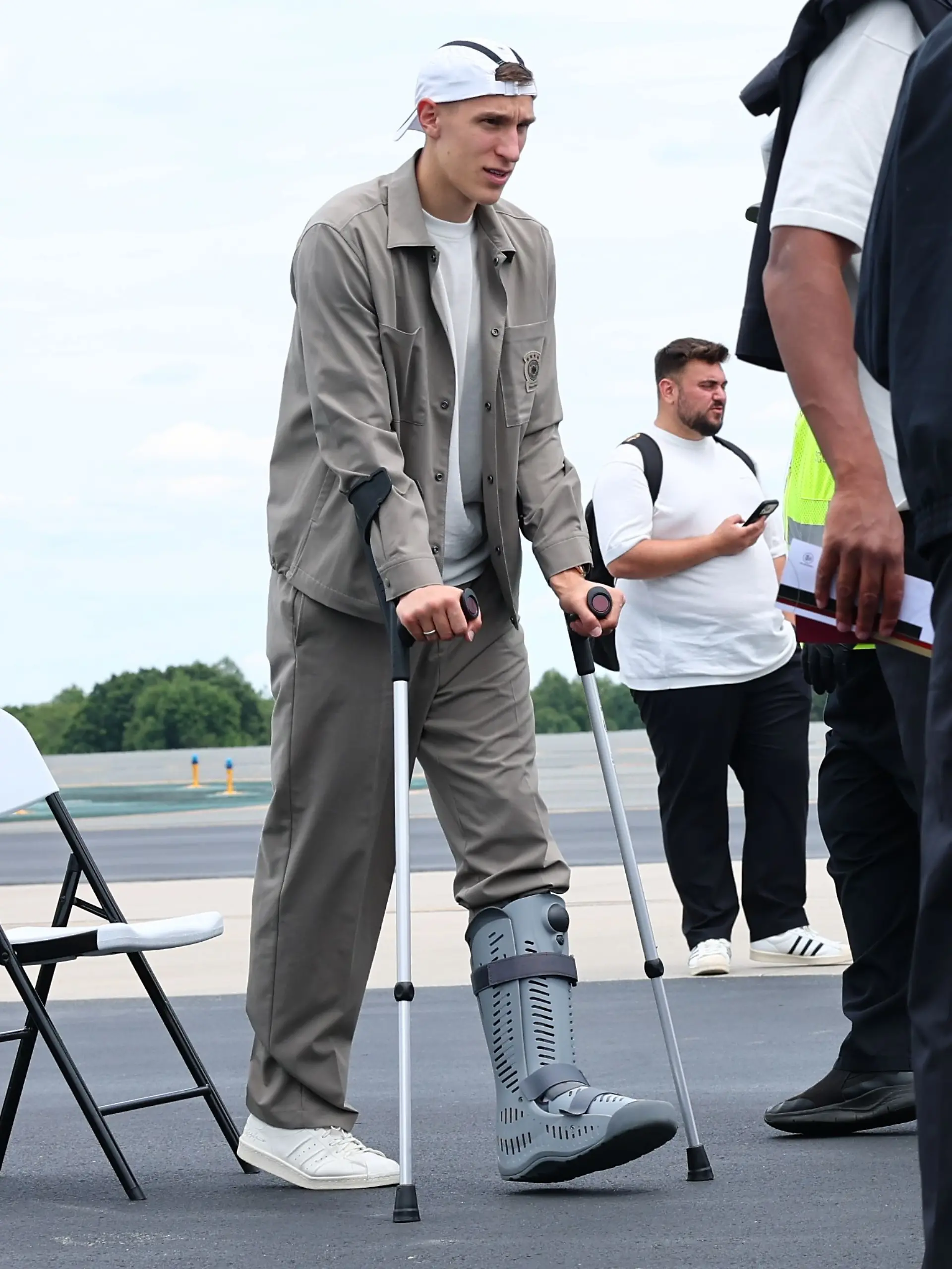 24.06.2026, USA, Winston-Salem: Fußball, WM 2026, Nationalmannschaft, Deutschland, Abreise zum dritten WM-Gruppenspiel gegen Ecuador vom Flughafen Smith Reynolds Airport, der verletzte Nico Schlotterbeck steht vor dem Abflug nach New York bei einer Sicherheitsüberprüfung an.