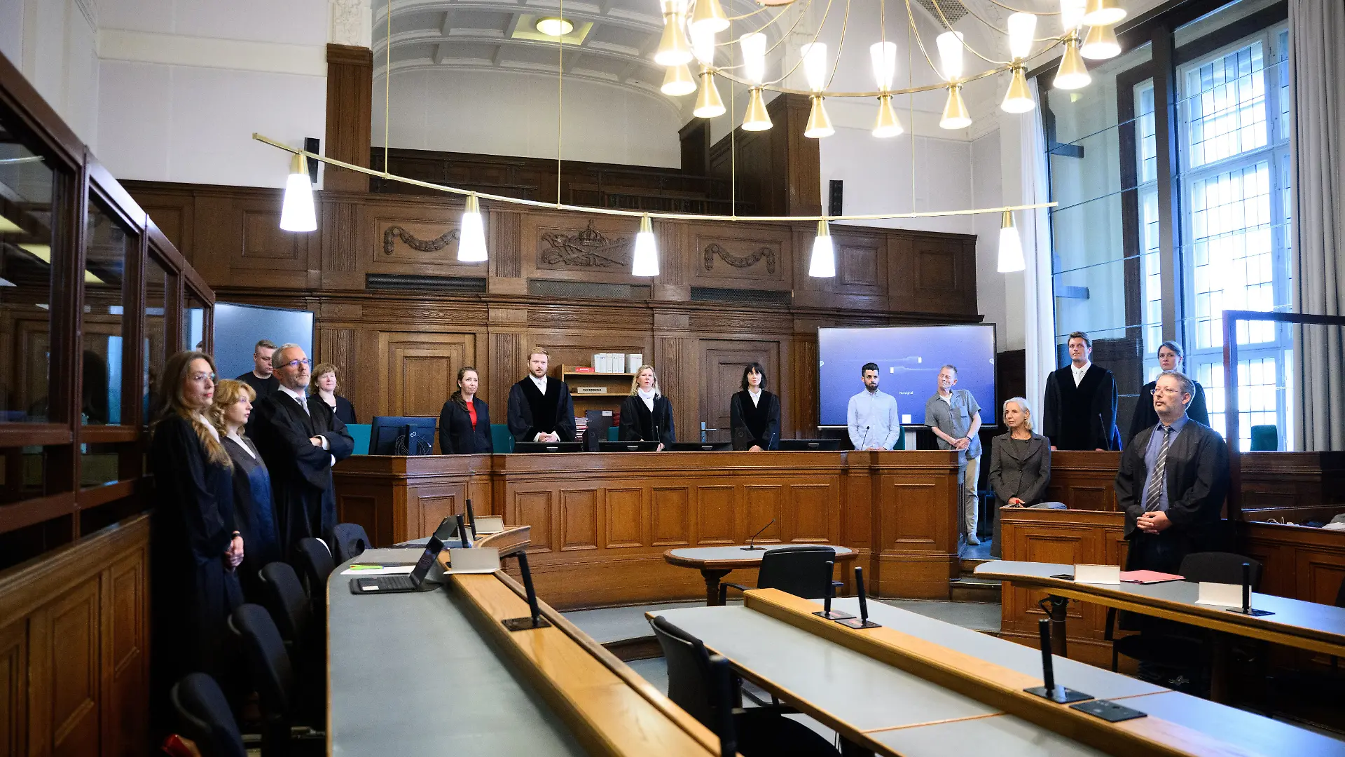 ARCHIV - 14.07.2025, Berlin: Die Prozessbeteiligten (l-r), die Rechtsanwälte des Angeklagten, Klaudia Dawidowic, Ria Halbritter und Christoph Stoll, sowie die Vorsitzende Richterin Sylvia Busch (M) und Staatsanwalt Philipp Meyhöfer (2.v.r.) stehen Ende Mai beim Mordprozess gegen einen Palliativarzt, der in Berlin 15 Menschen getötet haben soll, im Landgericht Berlin. (Archivbild) (zu dpa: «Berliner Palliativarzt gibt Tötung von Patienten zu»)