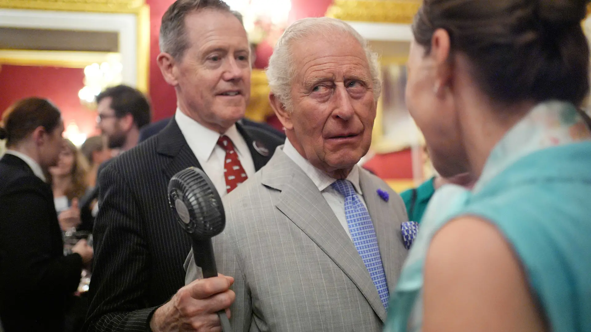 Vice Admiral Sir Tony Johnstone-Burt, Master of the Household to the Sovereign holds a small battery powered fan for King Charles III as he attends a London Climate Week reception, hosted by the Department for Energy Security and Net Zero (DESNZ), at St James's Palace, London. Picture date: Wednesday June 24, 2026., Credit:Yui Mok / PA ROTA - B68 / Avalon
