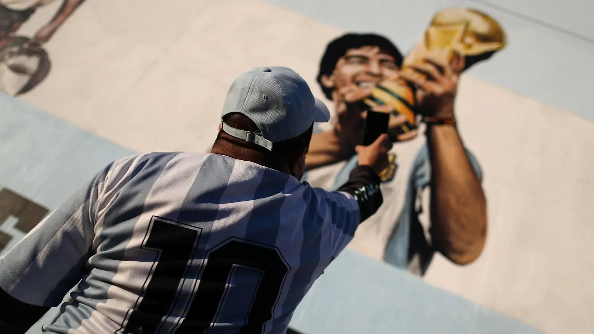 A fan of Argentine soccer superstar Diego Armado Maradona takes a picture of a mural as he celebrates the idol's 35th anniversary of the "goal of the century", against England during the 1986 World Cup played in Mexico, in Buenos Aires, Argentina June 22, 2021. REUTERS/Agustin Marcarian