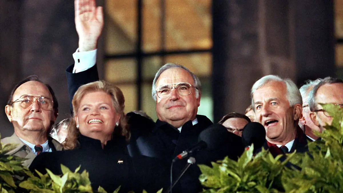 Die Deutschen sind wieder vereint: Bei der Berliner Feier am 3.10.1990 winken von der Freitreppe des Reichstagsgebäude (l-r) Bundesaußenminister Hans-Dietrich Genscher (FDP), Hannelore Kohl, Bundeskanzler Helmut Kohl (CDU) und Bundespräsident Richard von Weizsäcker, daneben halb verdeckt Lothar de Maiziere, der letzte DDR-Ministerpräsident. Die Deutschen sind 45 Jahre nach dem Ende des 2. Weltkrieges mit dem 3. Oktober 1990 wieder in einem souveränen Staat vereint. Die DDR ist der Bundesrepublik beigetreten und existiert nicht mehr. Der Untergang des SED-Regimes hatte sich in einem rasanten Tempo vollzogen: Am 9.11.1989 öffnete die DDR endgültig ihre Grenzen.