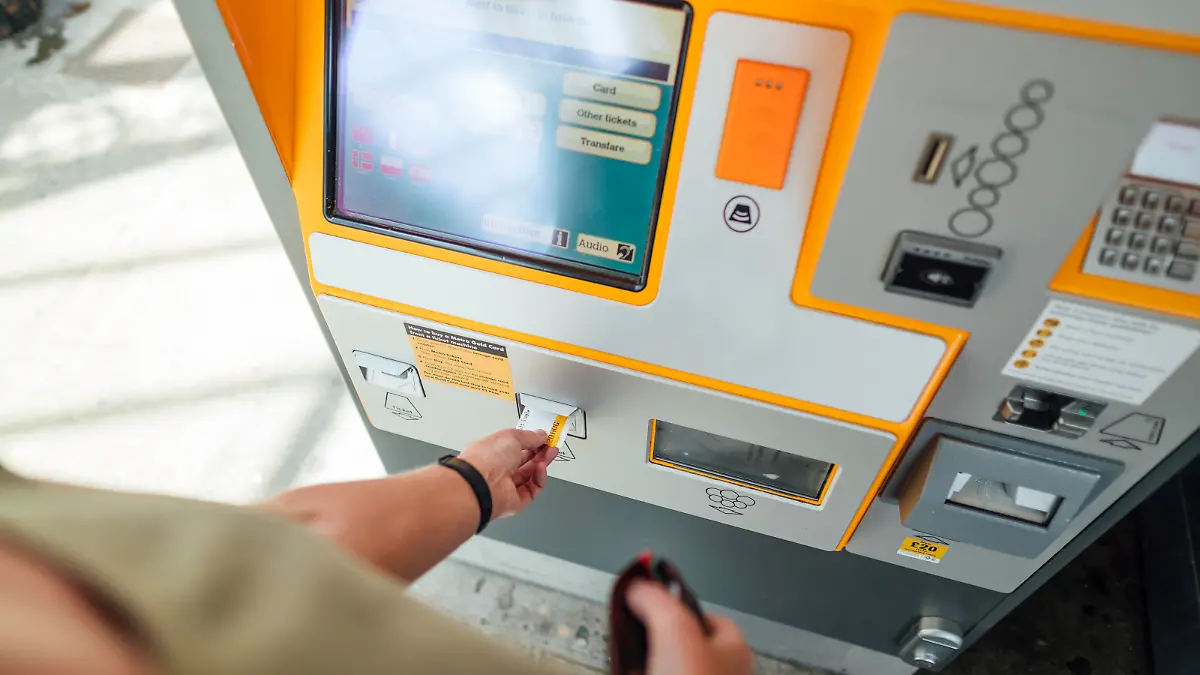 Man sieht, wie ein Mann sich am Ticketschalter einen gültigen Fahrschein ersteht.
