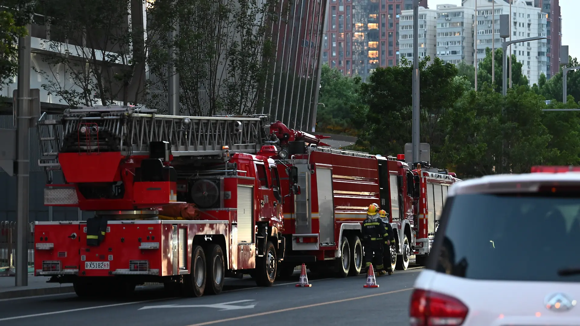 Einsatzfahrzeugen stehen beim Citic Tower, auch bekannt als Zun Tower. In Chinas Hauptstadt Peking ist offenbar ein Kleinflugzeug gegen das höchste Gebäude der Stadt geprallt. +++ dpa-Bildfunk +++