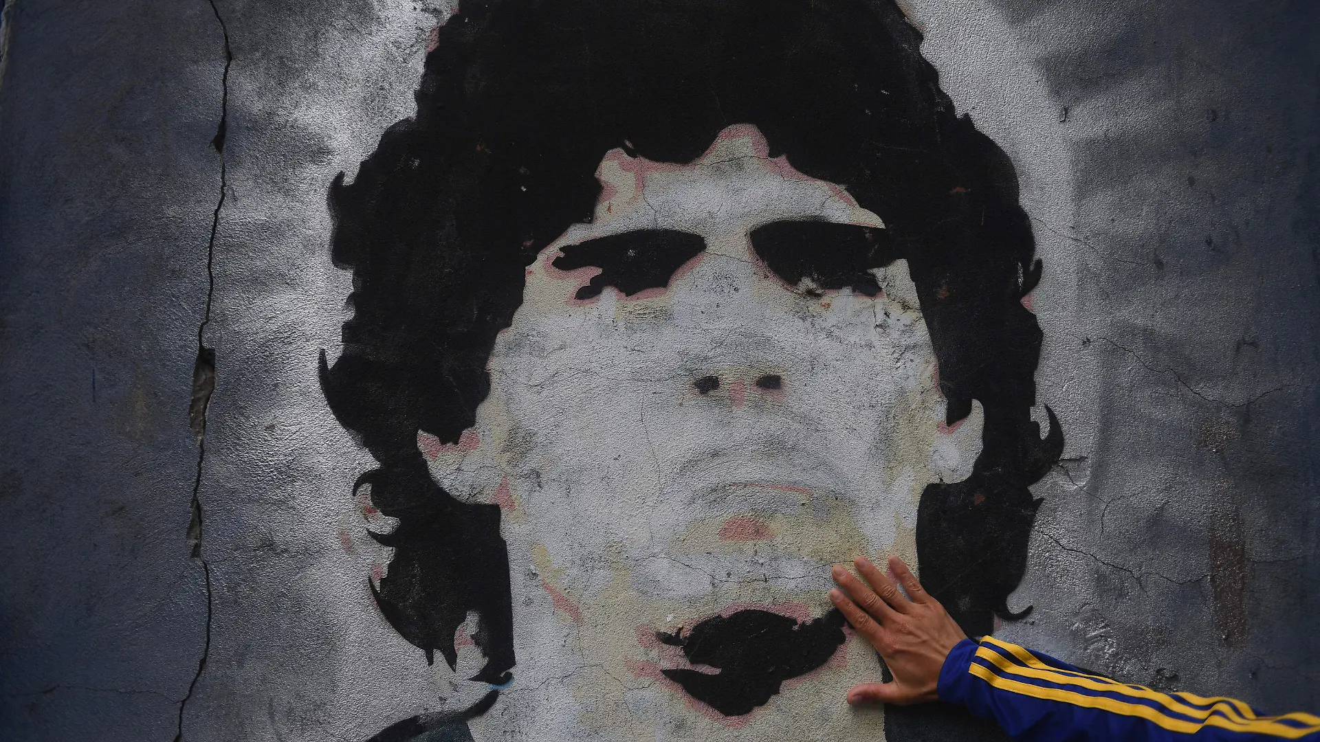 25.11.2020, Argentinien, Buenos Aires: Ein Fan trauert vor einem Wandgemälde mit der Abbildung des ehemaligen Fußballstars Maradona.  (zu dpa «Verbrechen oder Schicksal: Ermittlungen nach Tod von Maradona» vom 07.07.2021) Foto: Fernando Gens/dpa +++ dpa-Bildfunk +++