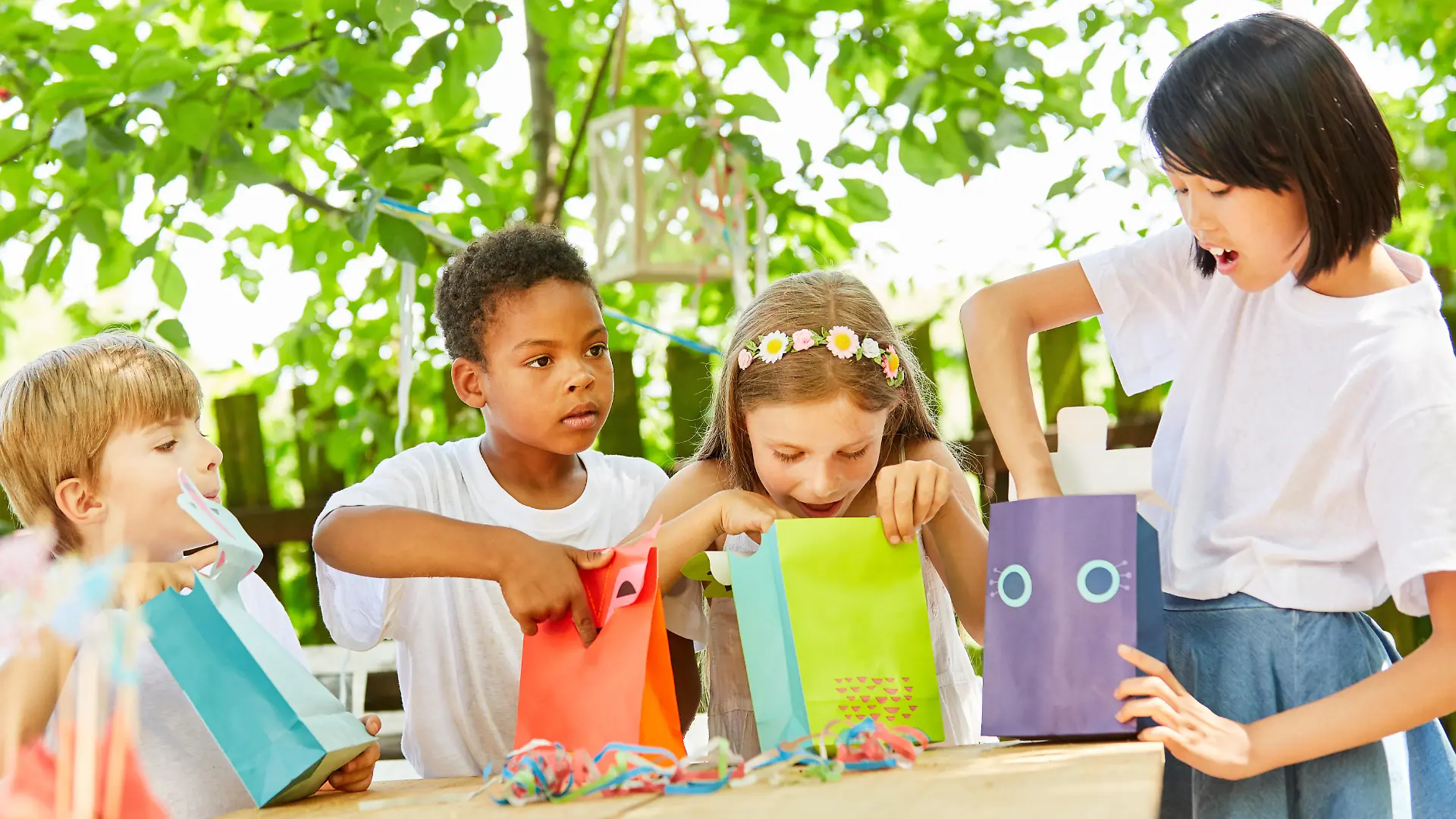 Kinder beim Auspacken von Mitgebseln auf einer Geburtstagsparty