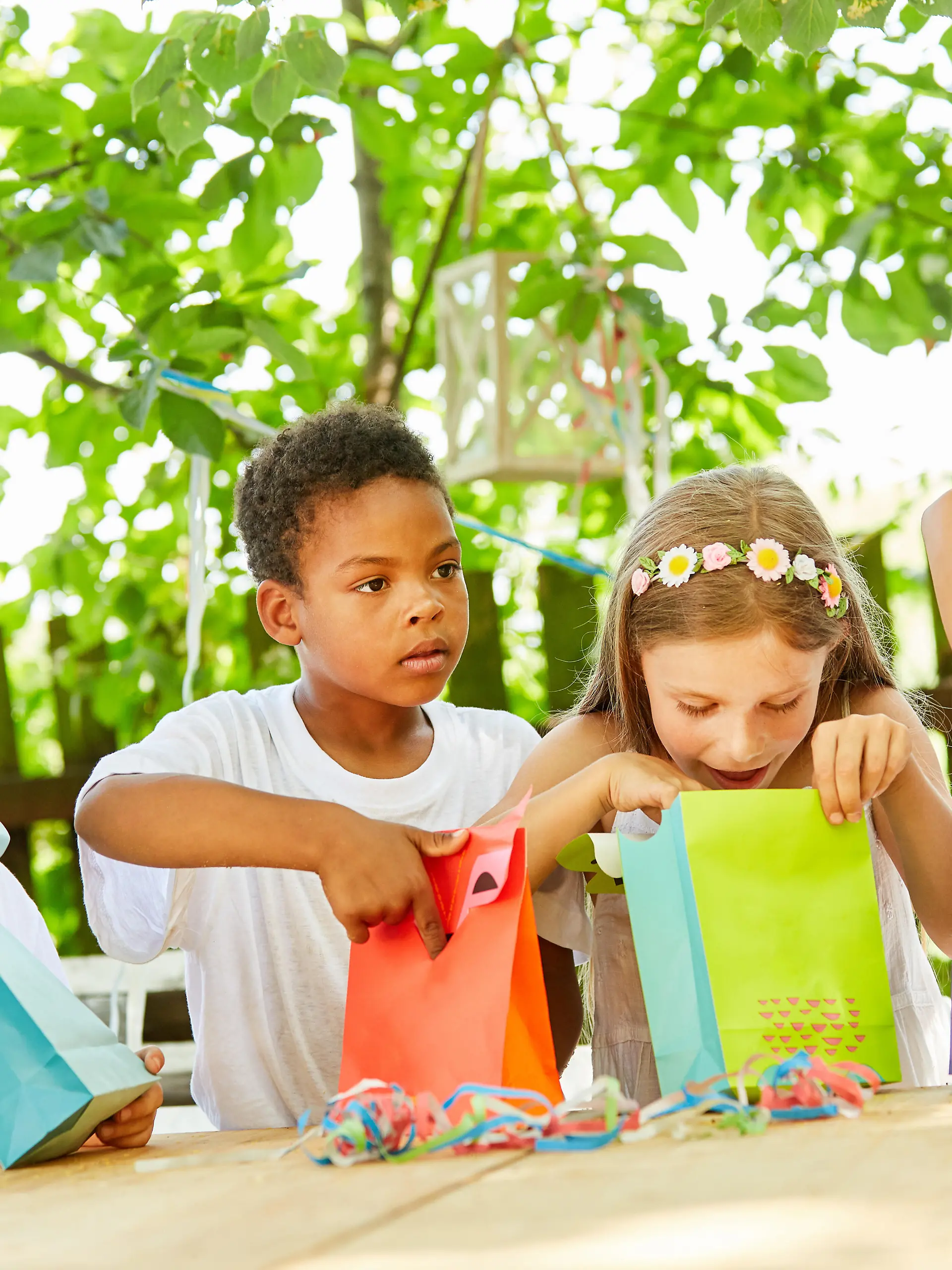 Kinder beim Auspacken von Mitgebseln auf einer Geburtstagsparty