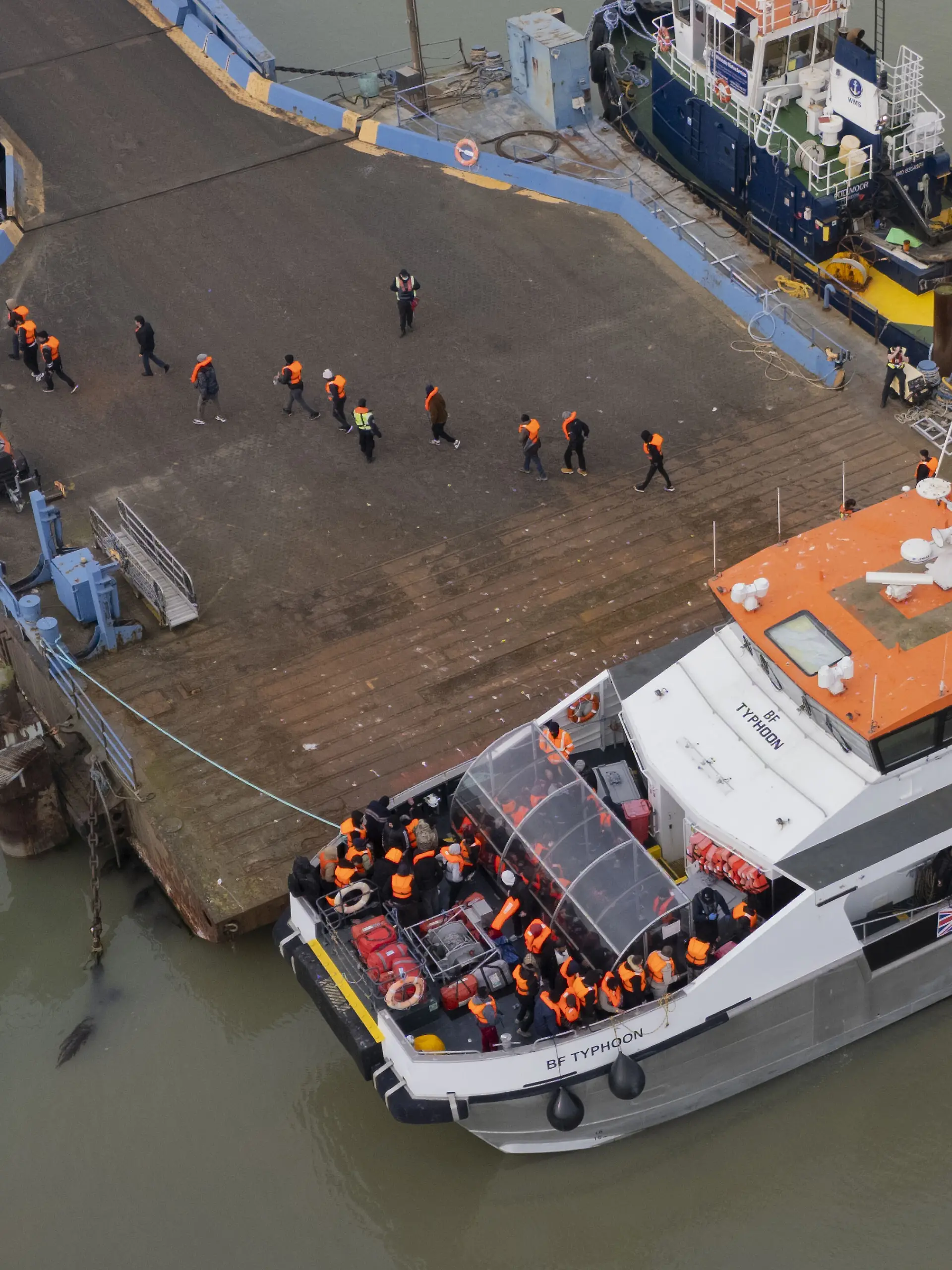 Eine Gruppe von Menschen, bei denen es sich vermutlich um Migranten handelt, kommt nach einem Zwischenfall mit einem kleinen Boot im Ärmelkanal an Bord eines Schiffes der Border Force im Hafen an. +++ dpa-Bildfunk +++