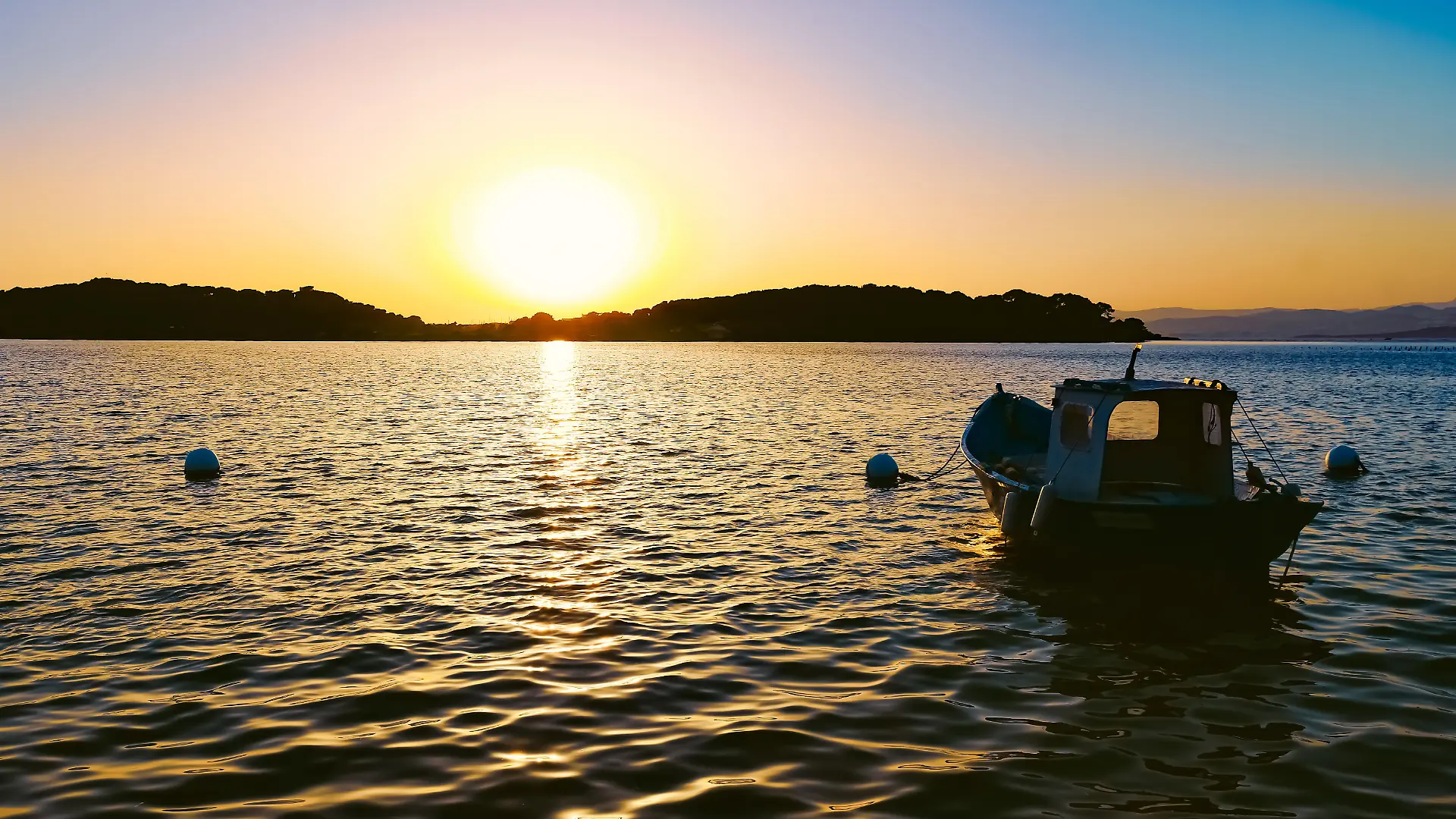 Kleines Boot im Meer in der untergehenden Sonne