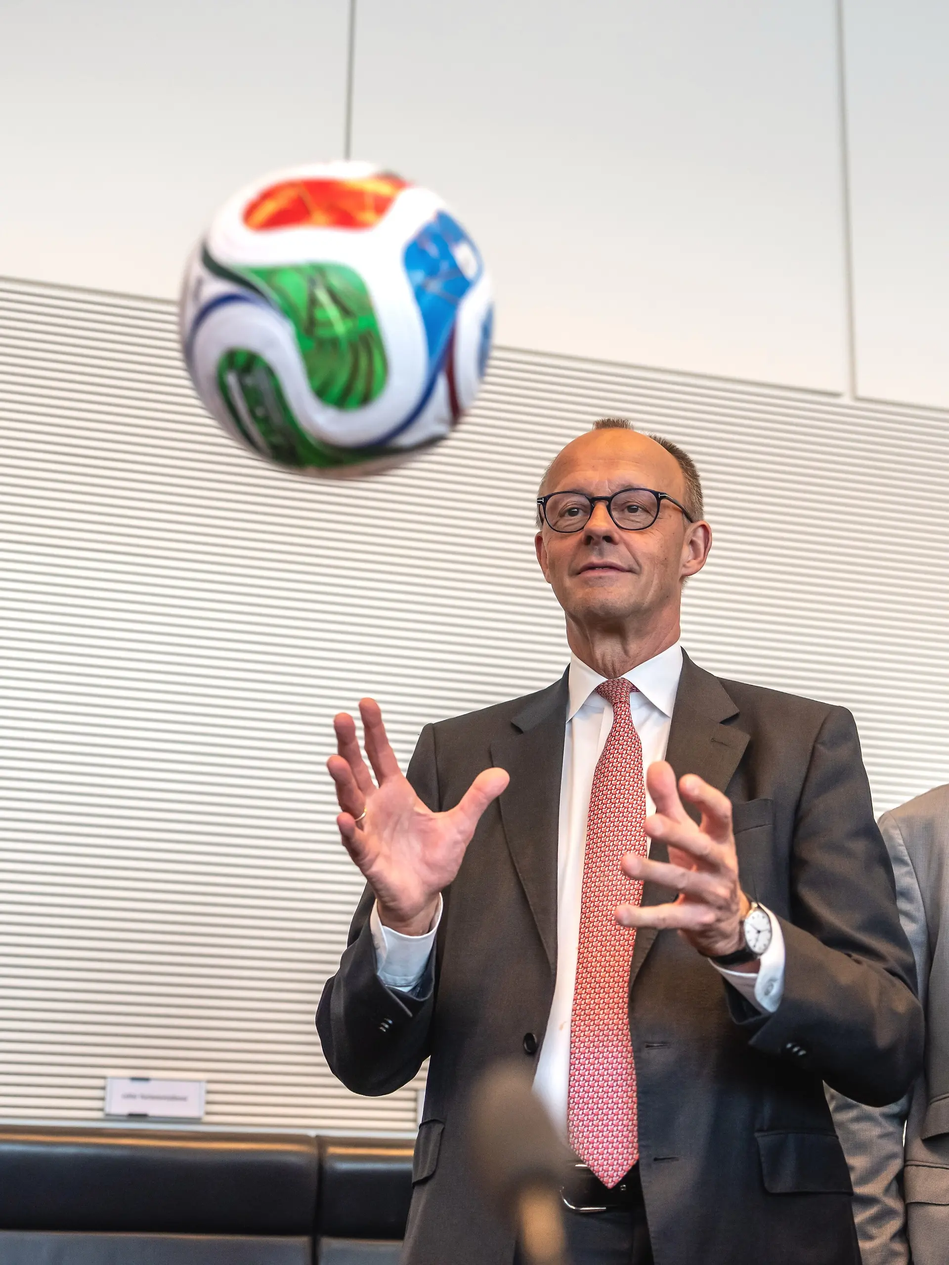 Bundeskanzler Friedrich Merz (CDU,M) fängt einen Fußball vor Beginn der Fraktionssitzung im Bundestag. +++ dpa-Bildfunk +++