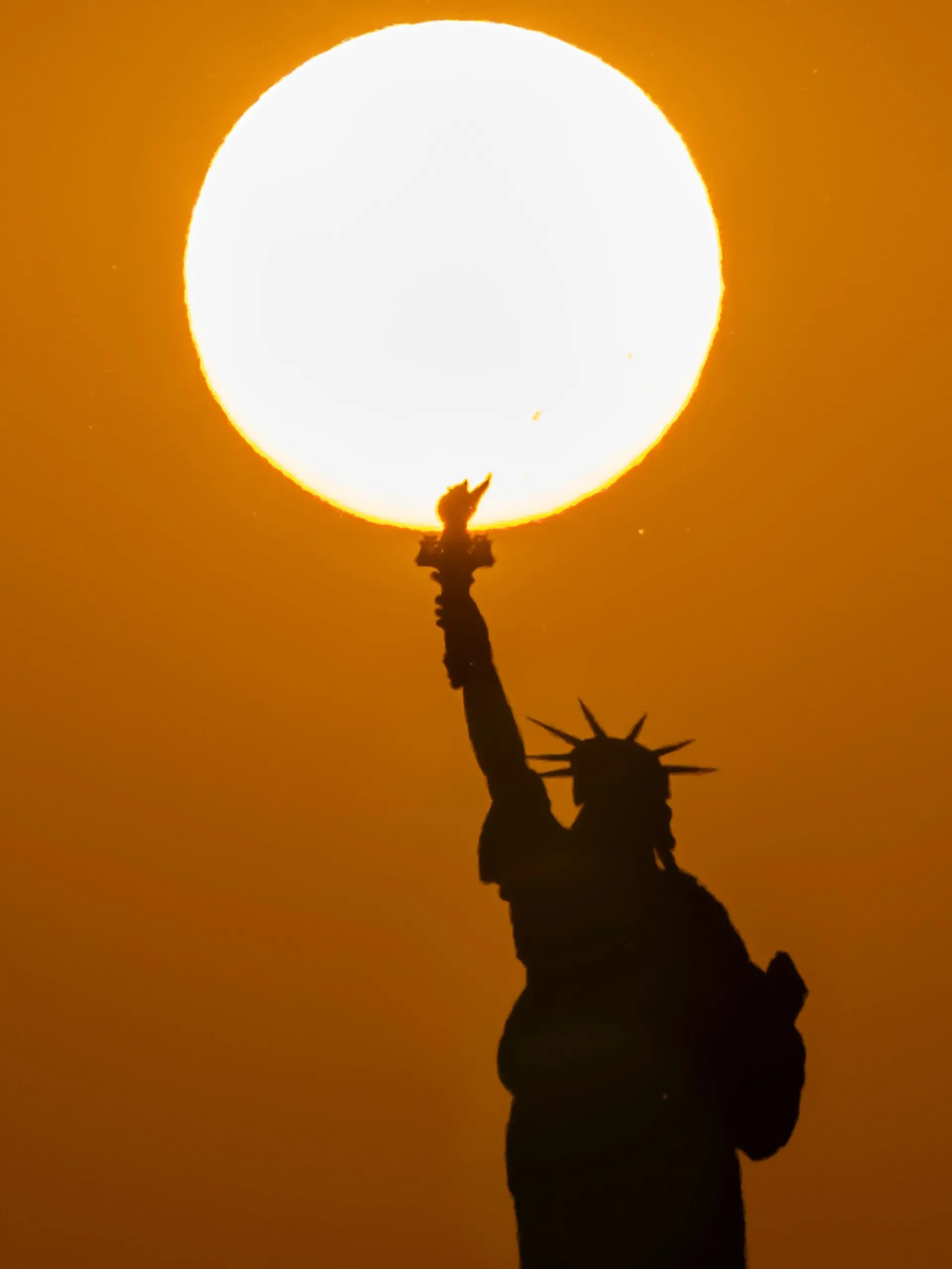 02.07.2026, USA, New York: Die Freiheitsstatue, während in New York die Sonne untergeht. Foto: Yuki Iwamura/AP/dpa +++ dpa-Bildfunk +++