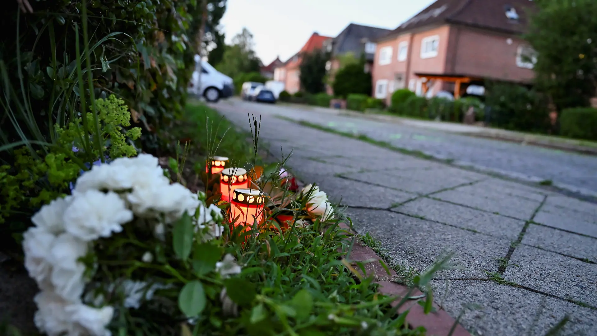 Flowers and candles sit in the ground near the scene after a deadly shooting at a youth welfare facility in the northern town of Stade, Germany, June 29, 2026. REUTERS/Jonas Walzberg