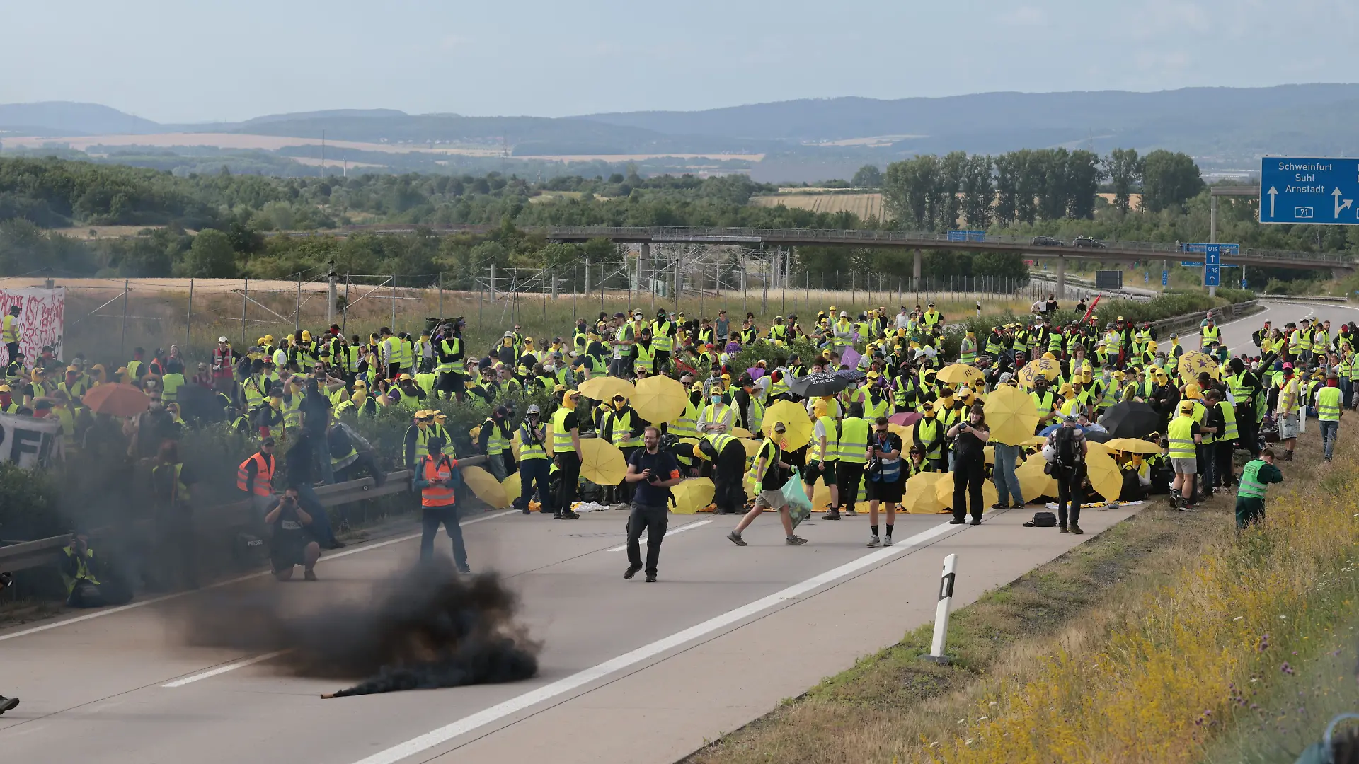04.07.2026, Thüringen, Erfurt: Demonstranten zünden Pyrotechnik und blockieren die Autobahn A71 nördlich des Erfurter Kreuzes bei Molsdorf, um Delegierten den Zugang zum AfD-Bundesparteitag zu erschweren. Der Bundesparteitag der AfD findet am 4. und 5. Juli in der Messe Erfurt statt. Foto: Michael Reichel/dpa +++ dpa-Bildfunk +++