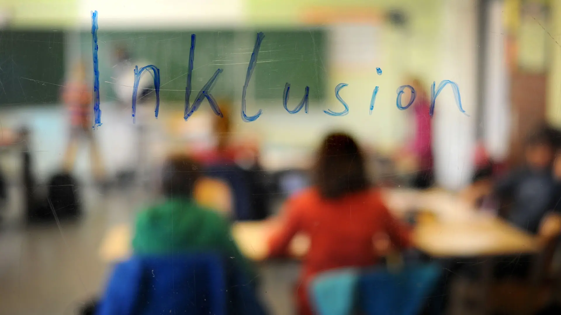 Schüler sitzen in einer Inklusions-Klasse unter dem Schriftzug «Inklusion».