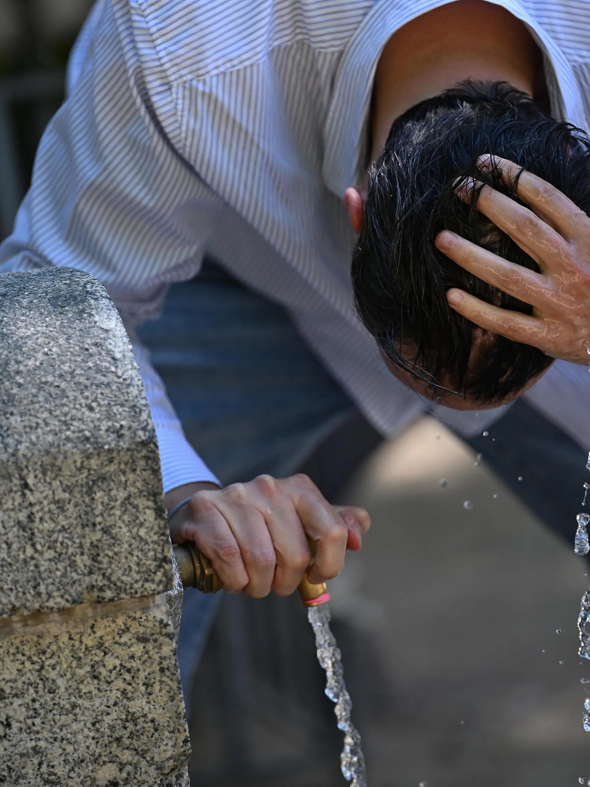 Ein Mann in Madrid versucht sich bei über 40 Grad etwas abzukühlen