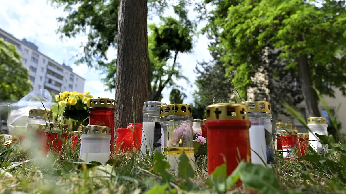 30.06.2021, Österreich, Wien: Kerzen und Blumen liegen am Fundort der Leiche eines erst 13 Jahre alten Mädchens. Nach dem Fund der Leiche eines 13-jährigen Mädchens in Wien hat die Polizei zwei Männer festgenommen. Die beiden Verdächtigen sind laut Behörden 16 und 18 Jahre alt. Foto: Herbert Neubauer/APA/dpa +++ dpa-Bildfunk +++