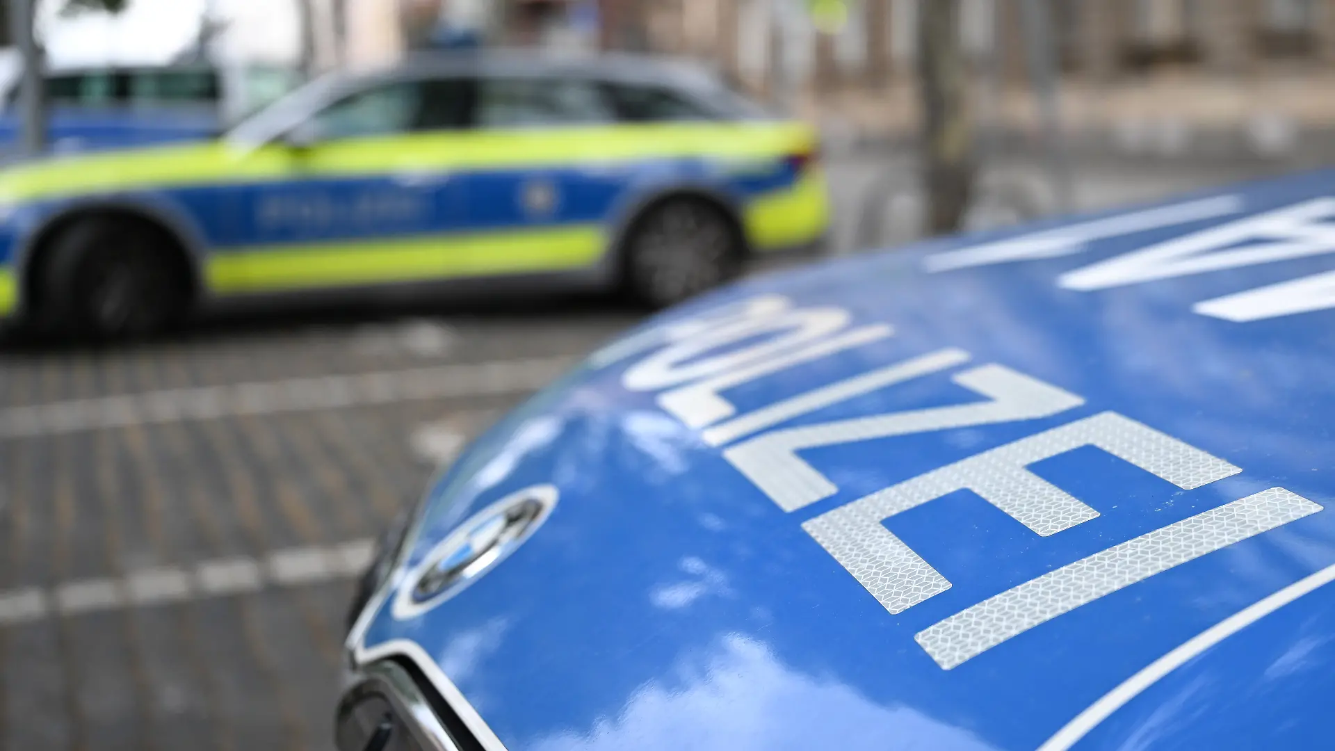 Polizeifahrzeuge stehen vor einer Polizeiwache. (zu dpa: «Polizei durchsucht zwölf Wohnungen nach Geiselnahme») +++ dpa-Bildfunk +++