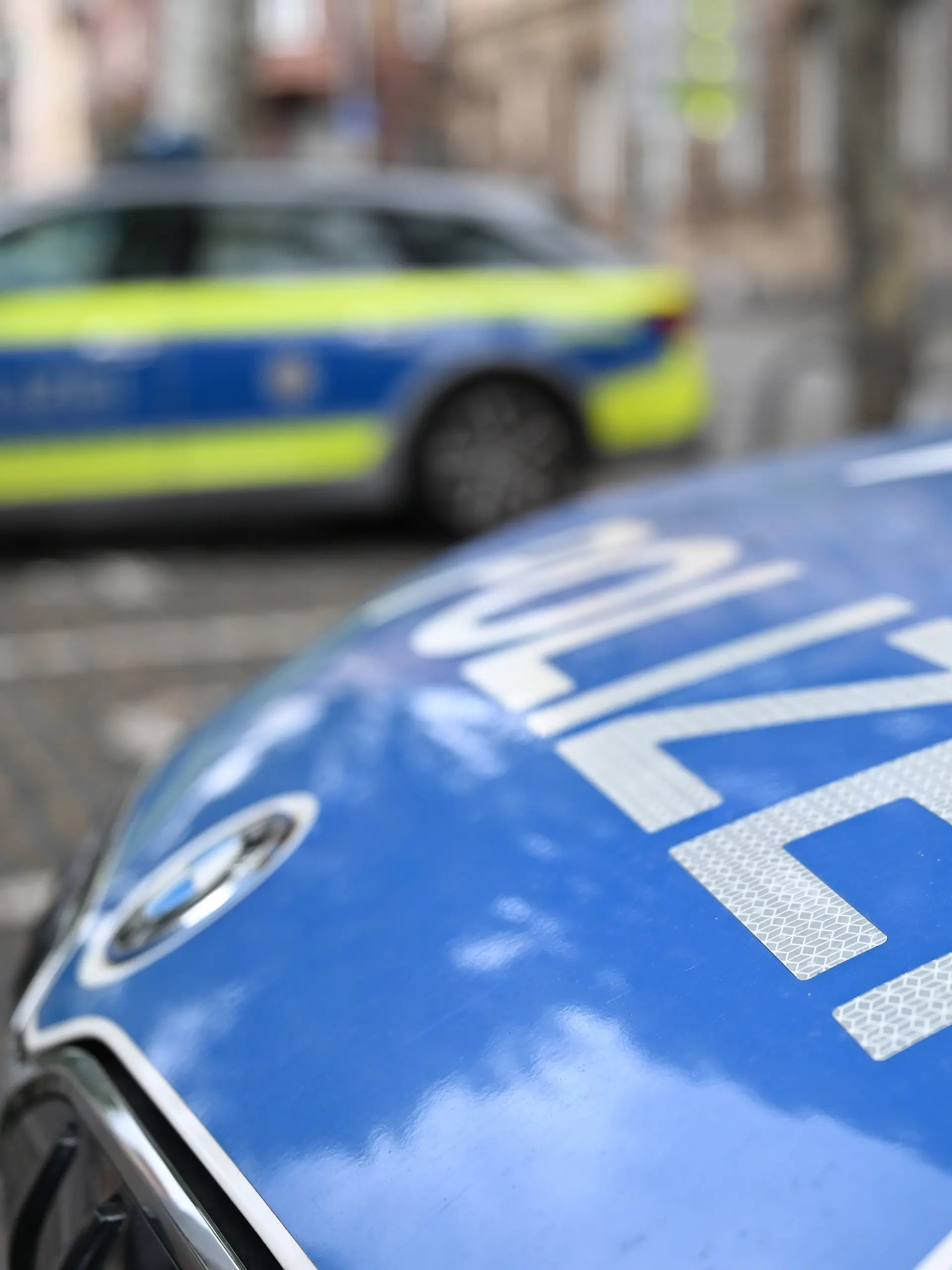 Polizeifahrzeuge stehen vor einer Polizeiwache. (zu dpa: «Polizei durchsucht zwölf Wohnungen nach Geiselnahme») +++ dpa-Bildfunk +++