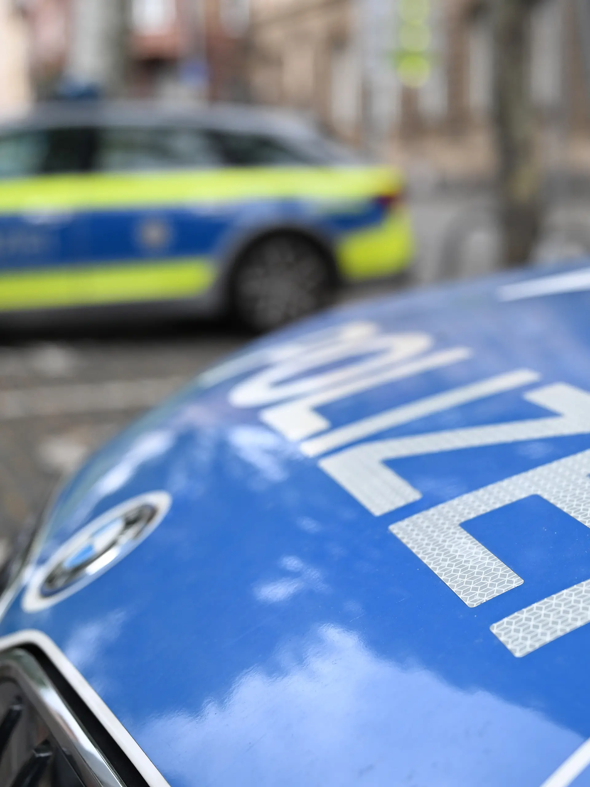Polizeifahrzeuge stehen vor einer Polizeiwache. (zu dpa: «Polizei durchsucht zwölf Wohnungen nach Geiselnahme») +++ dpa-Bildfunk +++