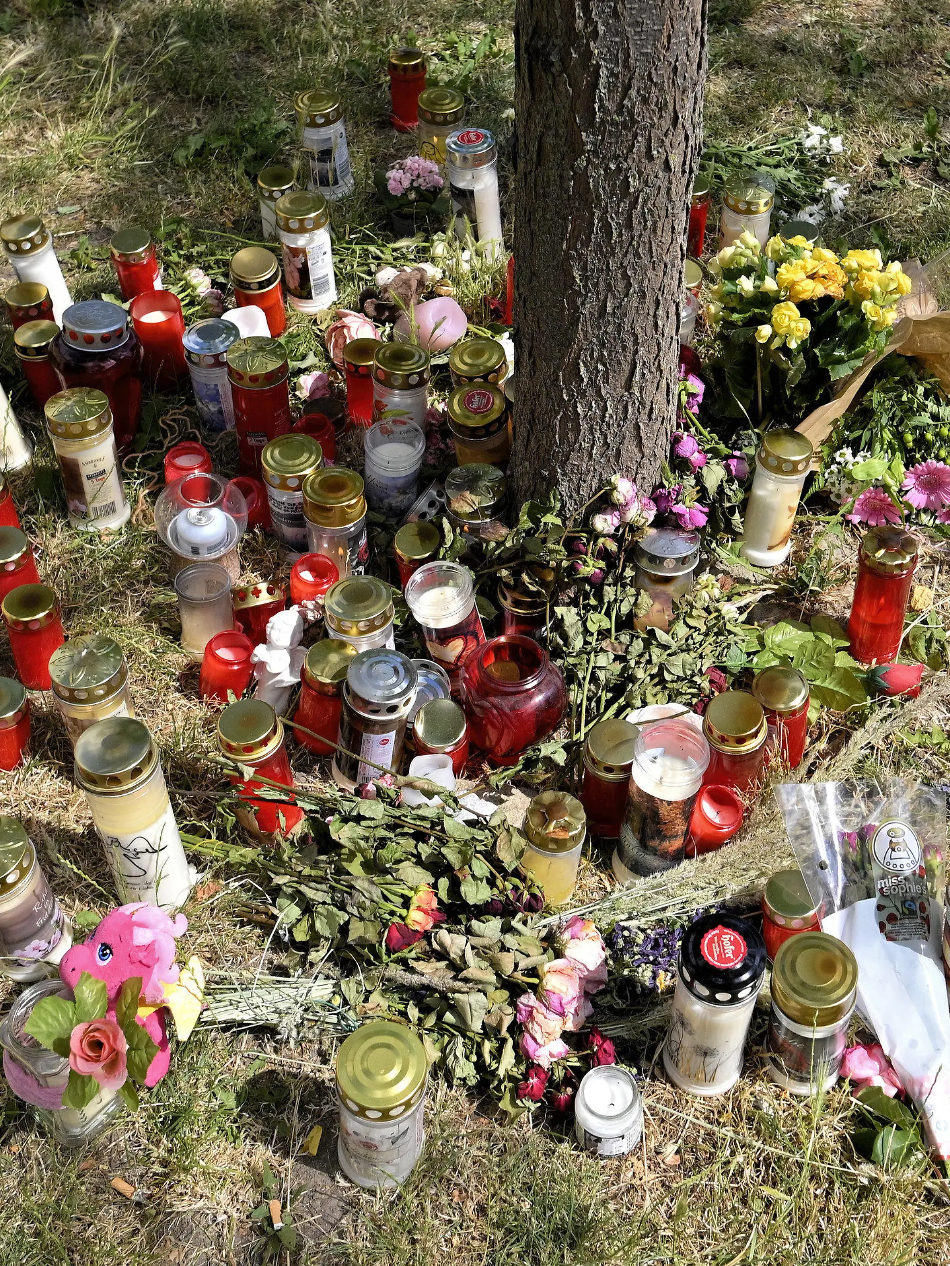 30.06.2021, Österreich, Wien: Kerzen und Blumen liegen am Fundort der Leiche eines erst 13 Jahre alten Mädchens. Nach dem Fund der Leiche eines 13-jährigen Mädchens in Wien hat die Polizei zwei Männer festgenommen. Die beiden Verdächtigen sind laut Behörden 16 und 18 Jahre alt. Foto: Herbert Neubauer/APA/dpa +++ dpa-Bildfunk +++
