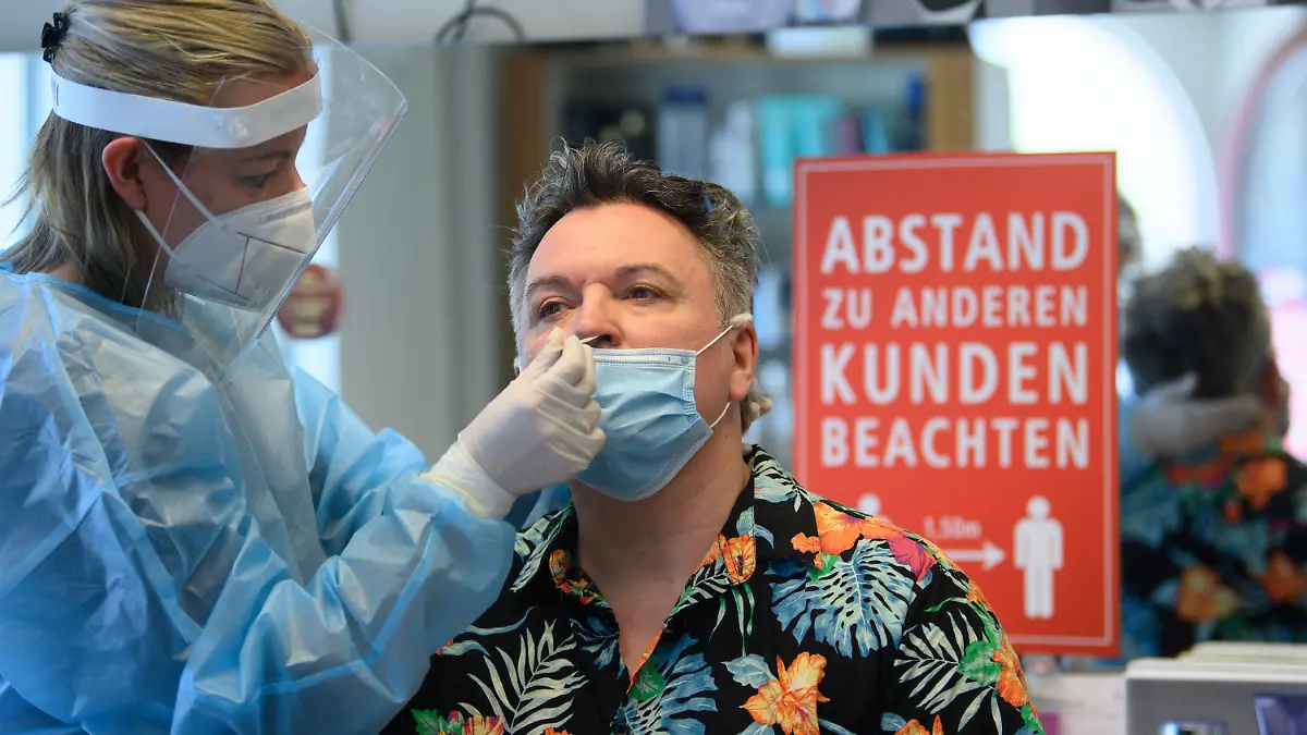 28.04.2021, Sachsen, Dresden: Eine Mitarbeiterin im Friseurstudio macht bei Friseurmeister Holger Knievel einen Antigen-Schnelltest auf das Coronavirus. Im Unternehmen werden alle Mitarbeiter zwei mal in der Woche getestet. Foto: Robert Michael/dpa-Zentralbild/dpa +++ dpa-Bildfunk +++