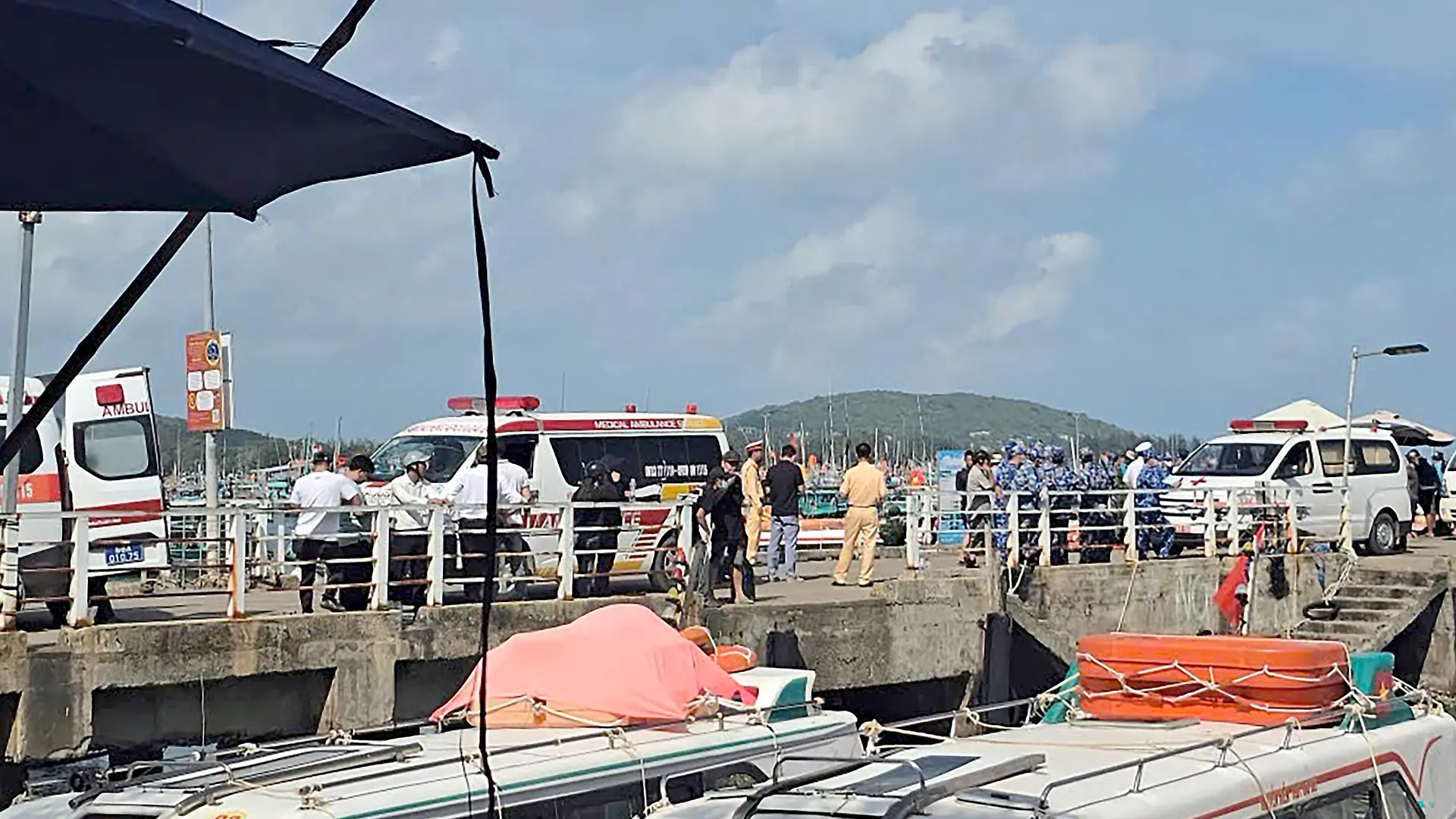 Ambulances line up on a pier to help victims of a boating accident after a tourist vessel capsized off Phu Quoc Island in southern Vietnam's An Giang Province on July 11, 2026. At least 15 people were killed when a tourist boat capsized off an island in Vietnam's south, state media reported on July 11. (Photo by AFP)