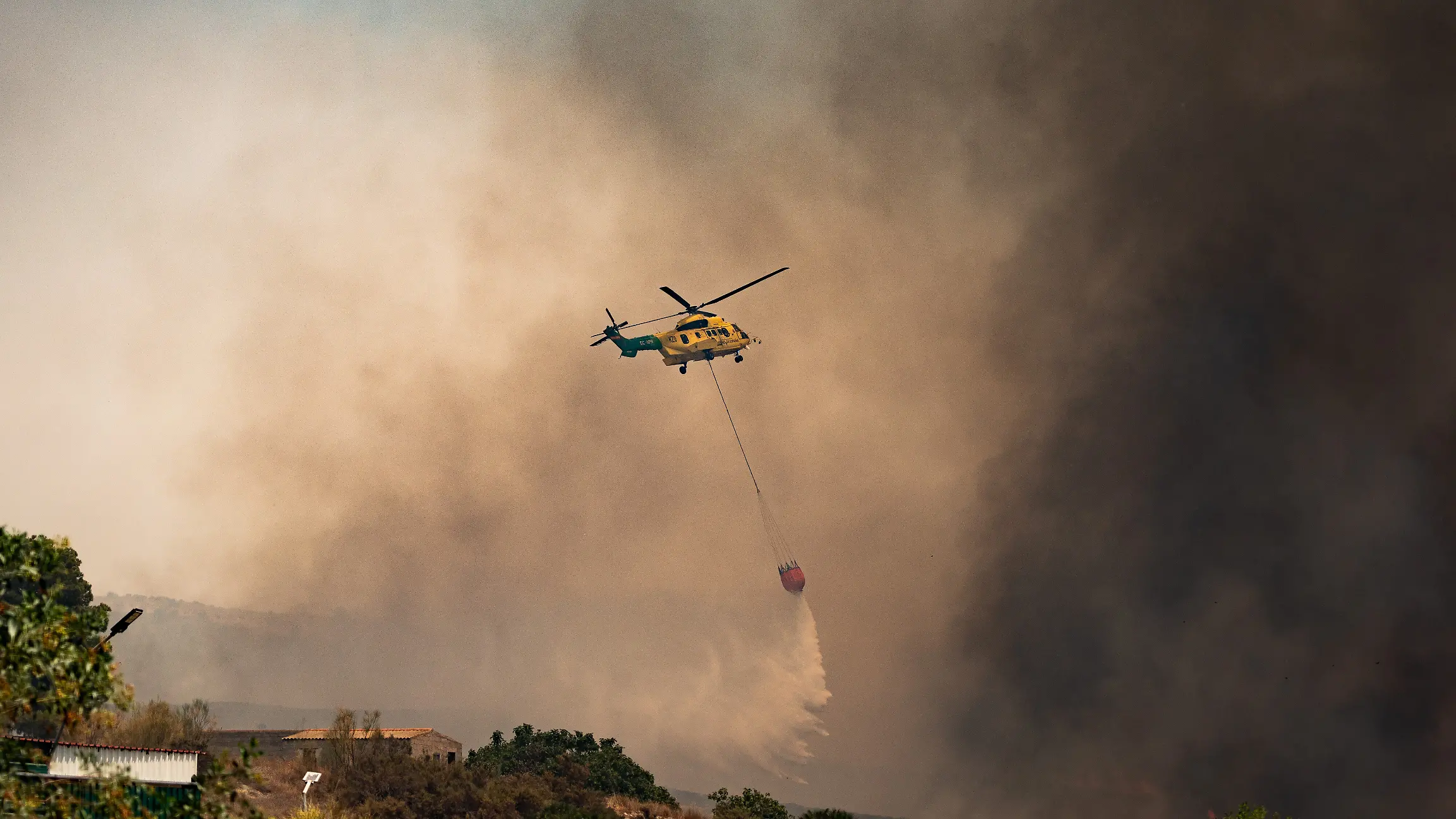 Ein Löschhubschrauber wirft über dem Waldbrand Wasser ab. Der Waldbrand in der Provinz Almería gilt als der bisher tödlichste des 21. Jahrhunderts in Spanien. Unter den Opfern befinden sich mutmaßlich auch Ausländer. +++ dpa-Bildfunk +++