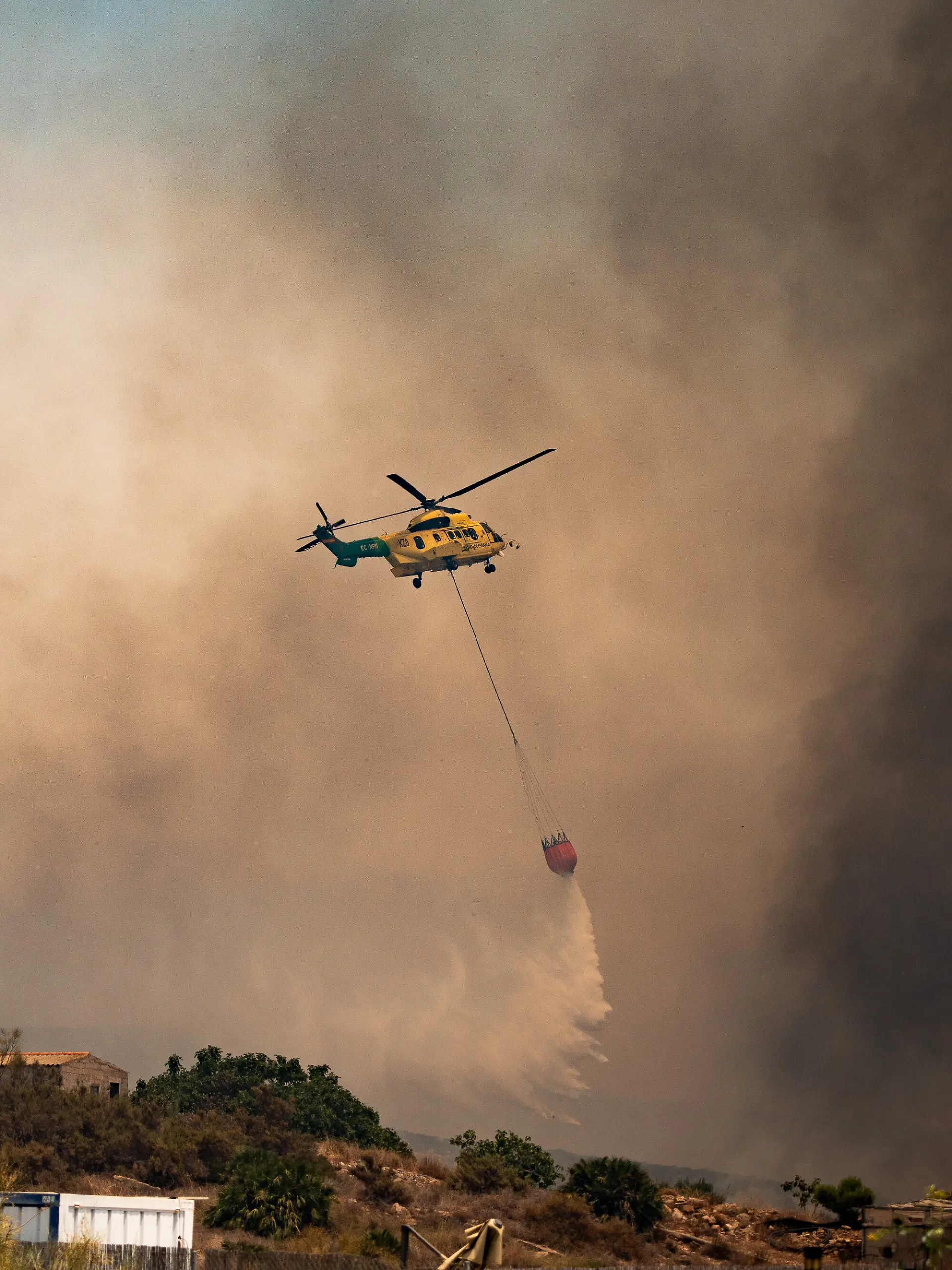 Ein Löschhubschrauber wirft über dem Waldbrand Wasser ab. Der Waldbrand in der Provinz Almería gilt als der bisher tödlichste des 21. Jahrhunderts in Spanien. Unter den Opfern befinden sich mutmaßlich auch Ausländer. +++ dpa-Bildfunk +++