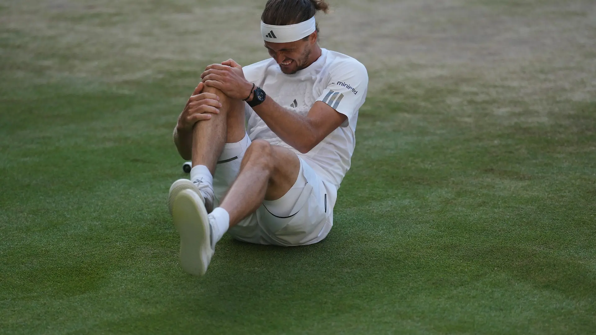 Alexander Zverev of Germany reacts after falling over during a point against Jannik Sinner of Italy in the men's singles final at Wimbledon Tennis Championships in London, Sunday, July 12, 2026. (AP Photo/Kirsty Wigglesworth)