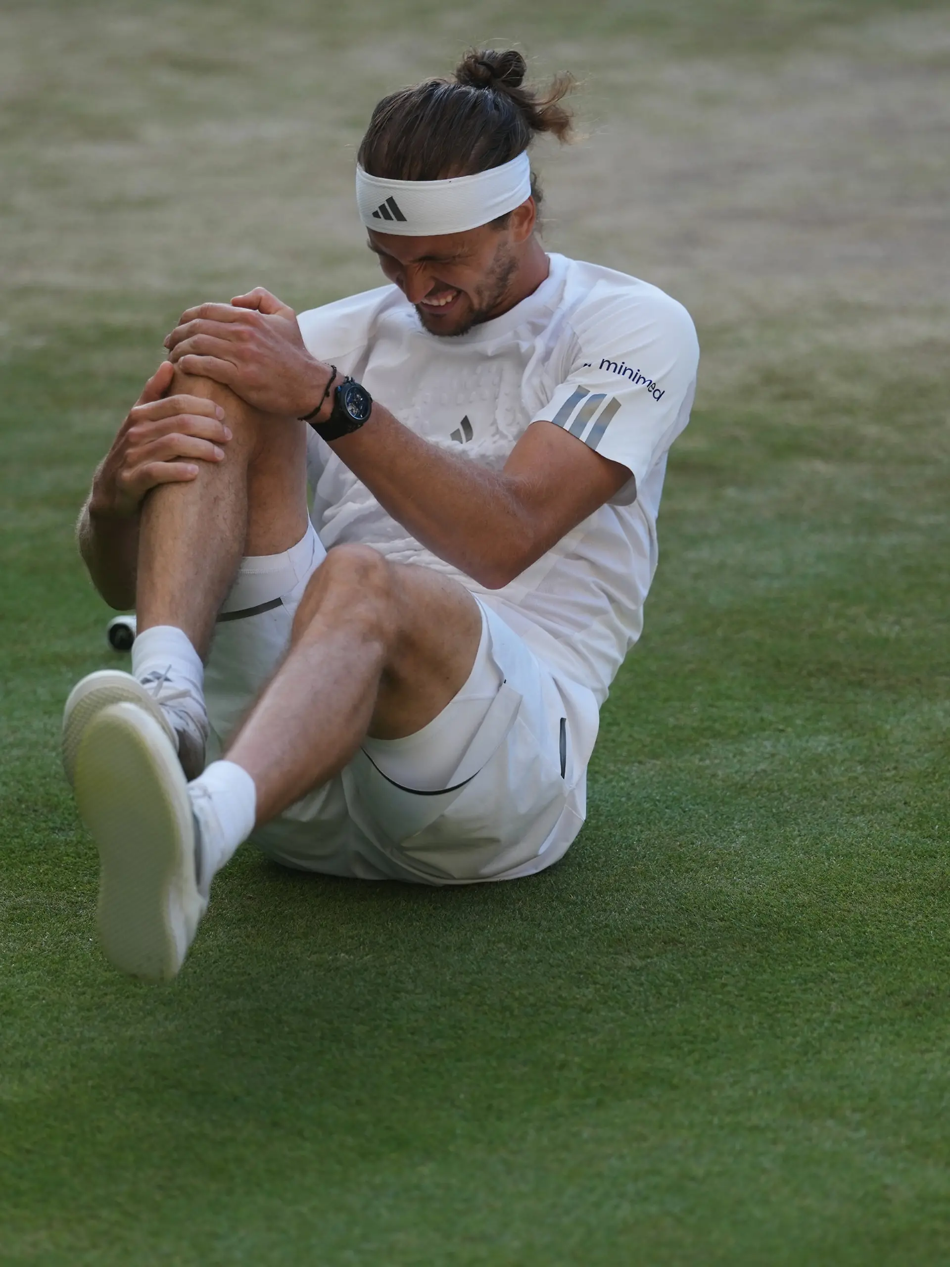 Alexander Zverev of Germany reacts after falling over during a point against Jannik Sinner of Italy in the men's singles final at Wimbledon Tennis Championships in London, Sunday, July 12, 2026. (AP Photo/Kirsty Wigglesworth)