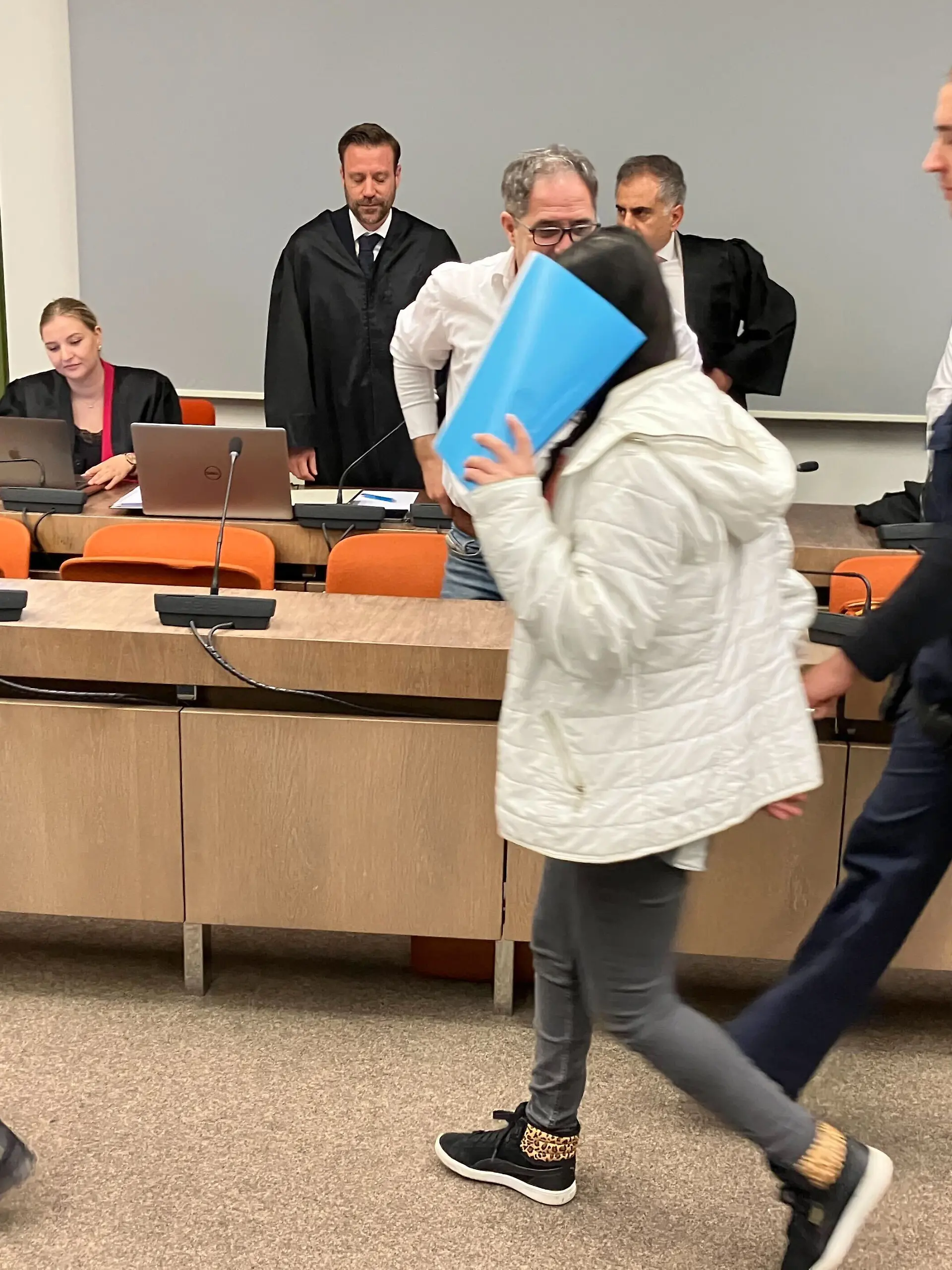 Justizbeamte bringen die angeklagte irakische Frau (M) in den Saal des Oberlandesgerichts. Das irakische Ehepaar ist angeklagt Versklavung, Vergewaltigung und Verbrechen gegen die Menschlichkeit. Das Paar soll laut Ermittlern als Teil der Terrororganisation Islamischer Staat (IS) zwei jesidische Mädchen als Sklavinnen gekauft, ausgebeutet und sexuell missbraucht haben.