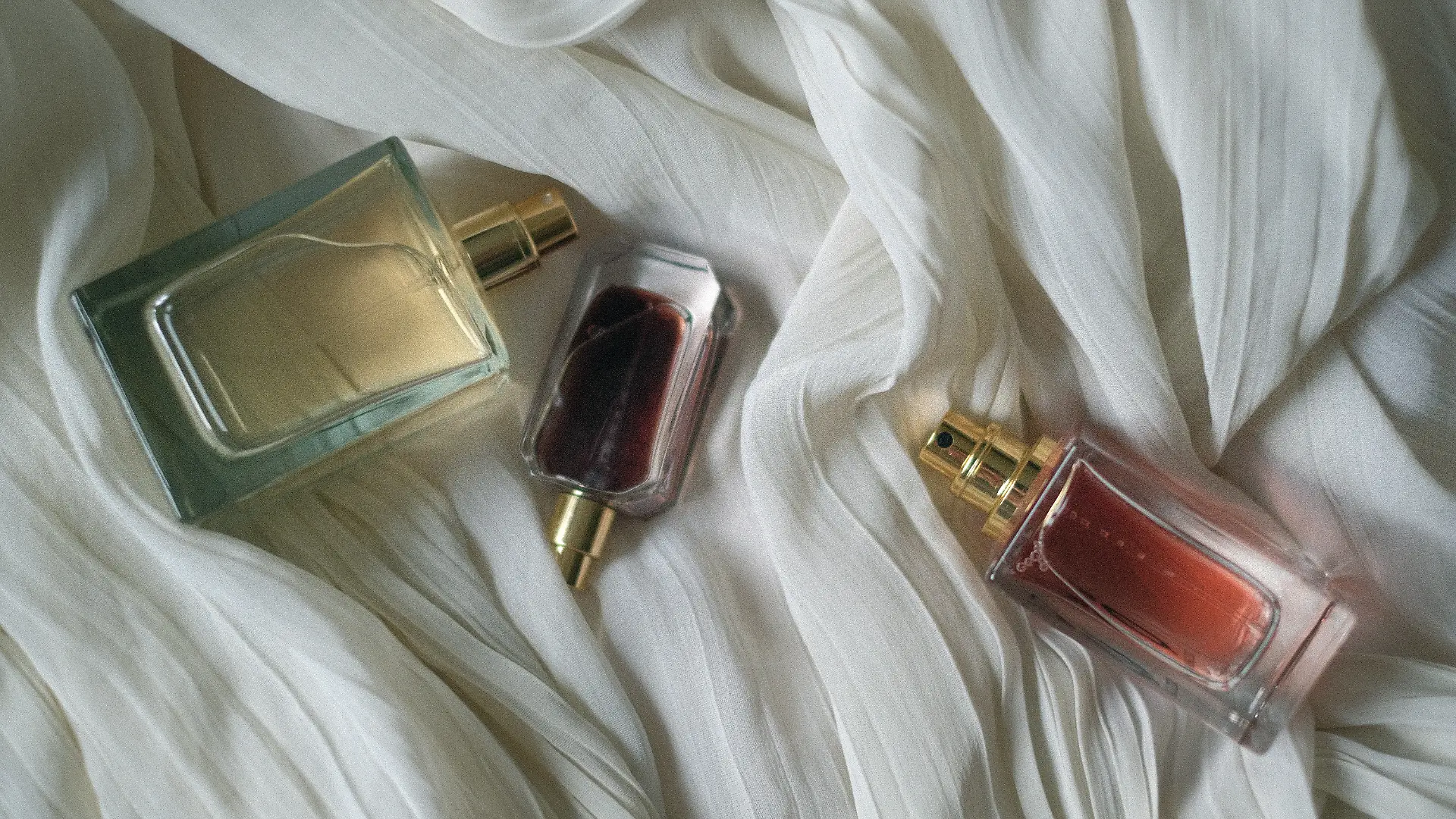 Drei Parfums auf einem Tuch