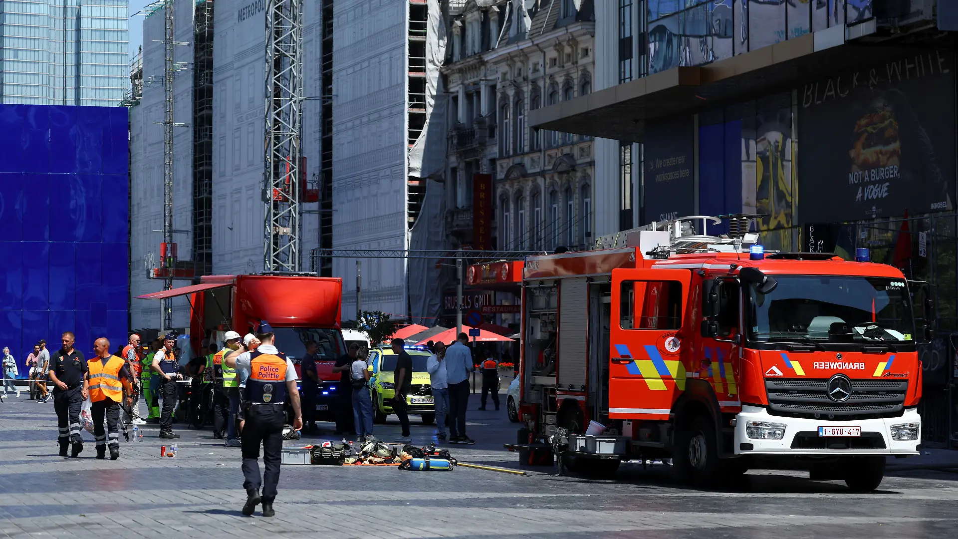 A member of the police walks near a fire truck, following a fire at Oxy Brussels building in Brussels, Belgium, July 14, 2026. REUTERS/Yves Herman