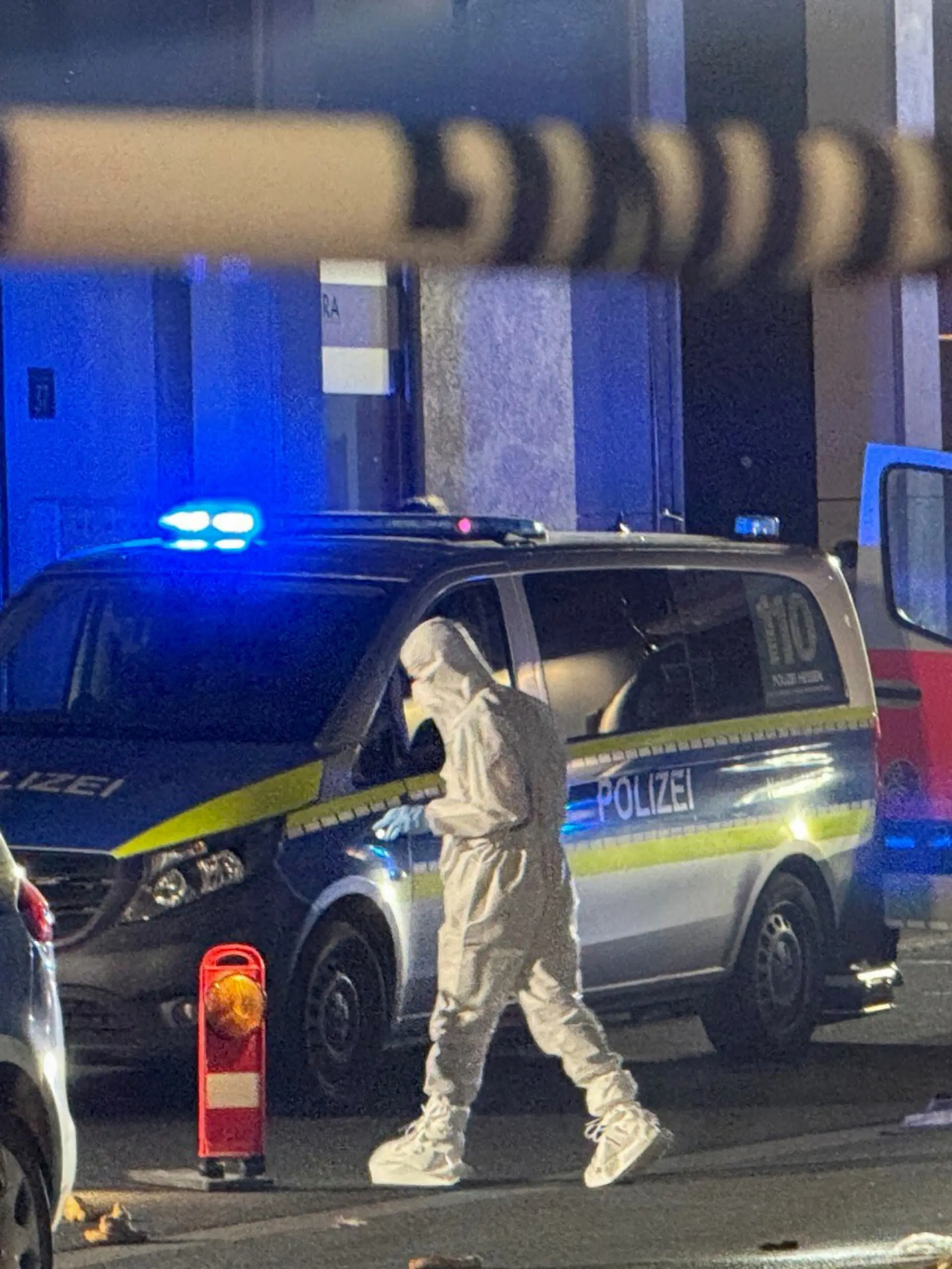 Mitarbeiter der Spurensicherung sind am Tatort in Kelkheim beschäftigt. Auf offener Straße hat ein Mann mit einer Schnittwaffe im hessischen Kelkheim seine Ehefrau getötet.