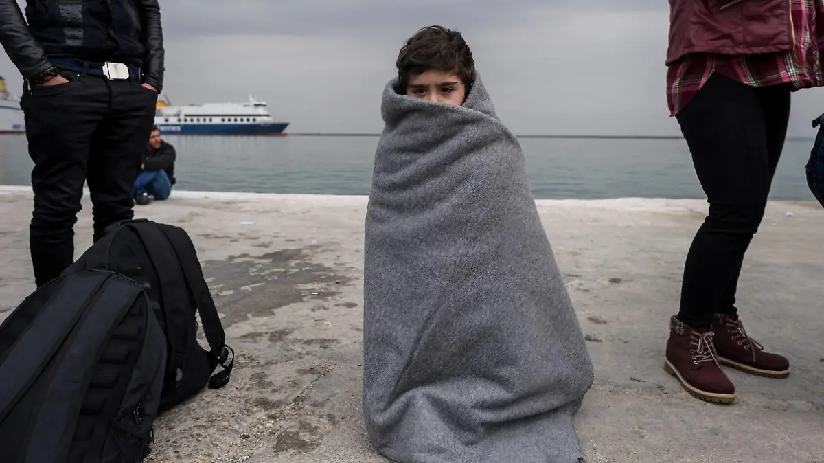  Flüchtlinge auf Lesbos - Fotostory Ein Kind steht am 02.03.2016 im Hafen von Mytilini, Griechenland eingehuellt in eine Decke. Europa stellt einen Fonds fuer eine humanitaere Krise innerhalb der EU mit 700 Millionen Euro Nothilfe bereit.