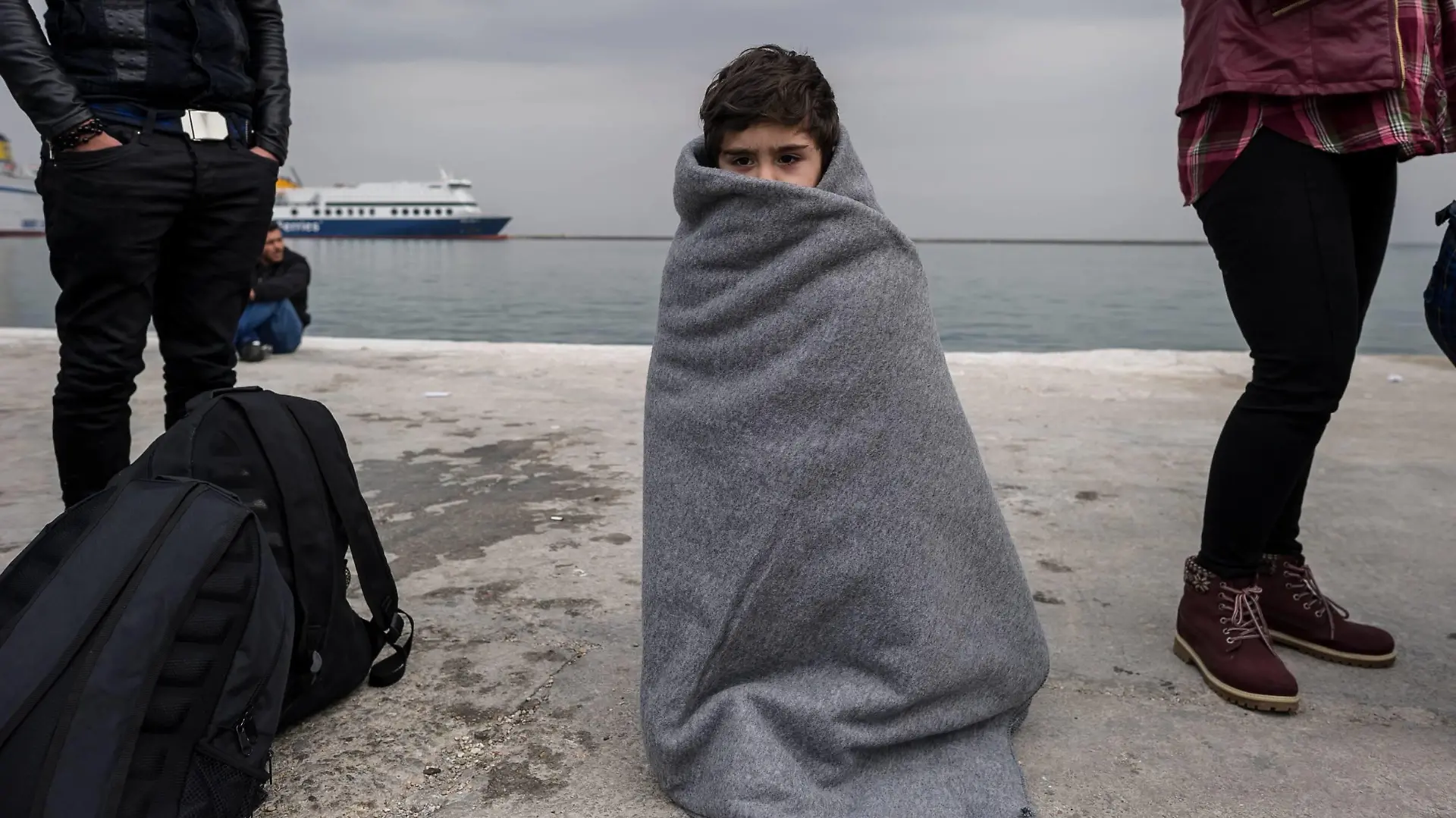 Flüchtlinge auf Lesbos - Fotostory Ein Kind steht am 02.03.2016 im Hafen von Mytilini, Griechenland eingehuellt in eine Decke. Europa stellt einen Fonds fuer eine humanitaere Krise innerhalb der EU mit 700 Millionen Euro Nothilfe bereit.